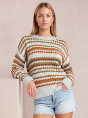 Model wears a light gray striped eyelet-patterned drop-shoulder sweater with brown and orange accents, ribbed trim, and a relaxed silhouette.