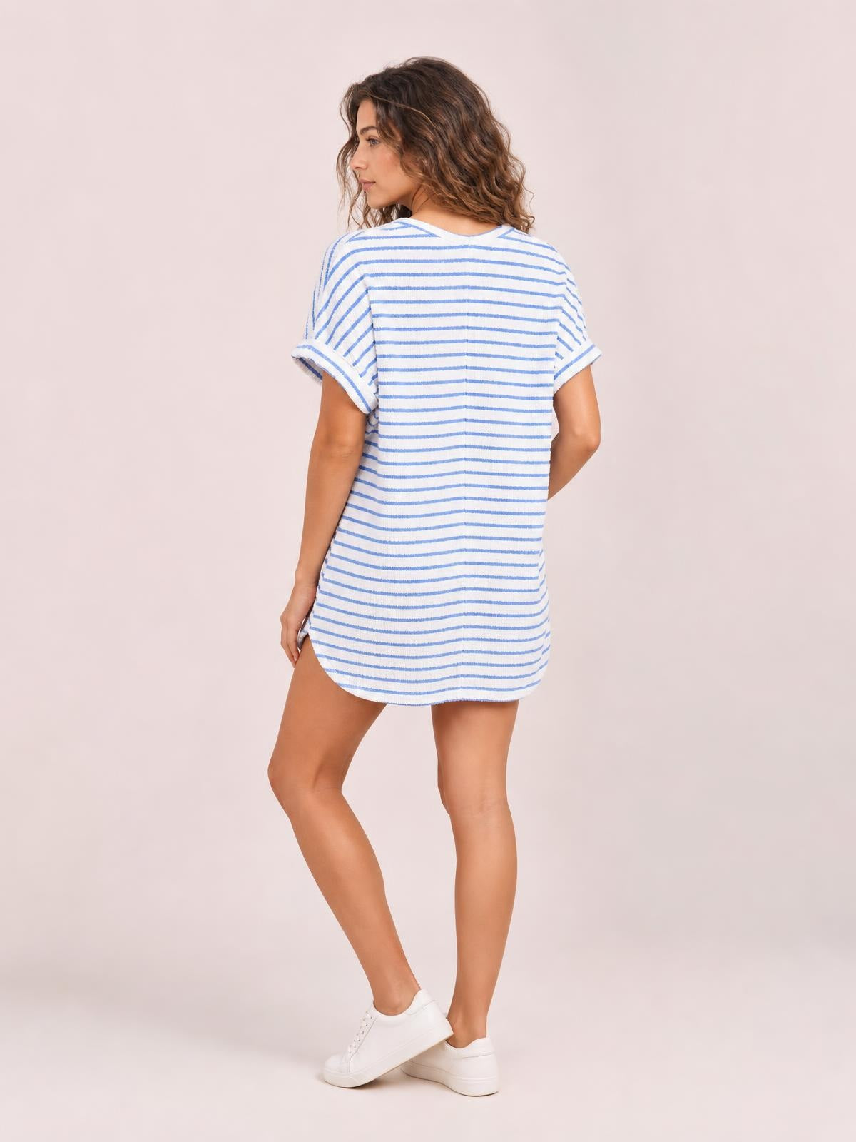A model poses in a blue-and-white striped knitted short-sleeve top with a relaxed silhouette and rounded hem from the coordinating shorts set.
