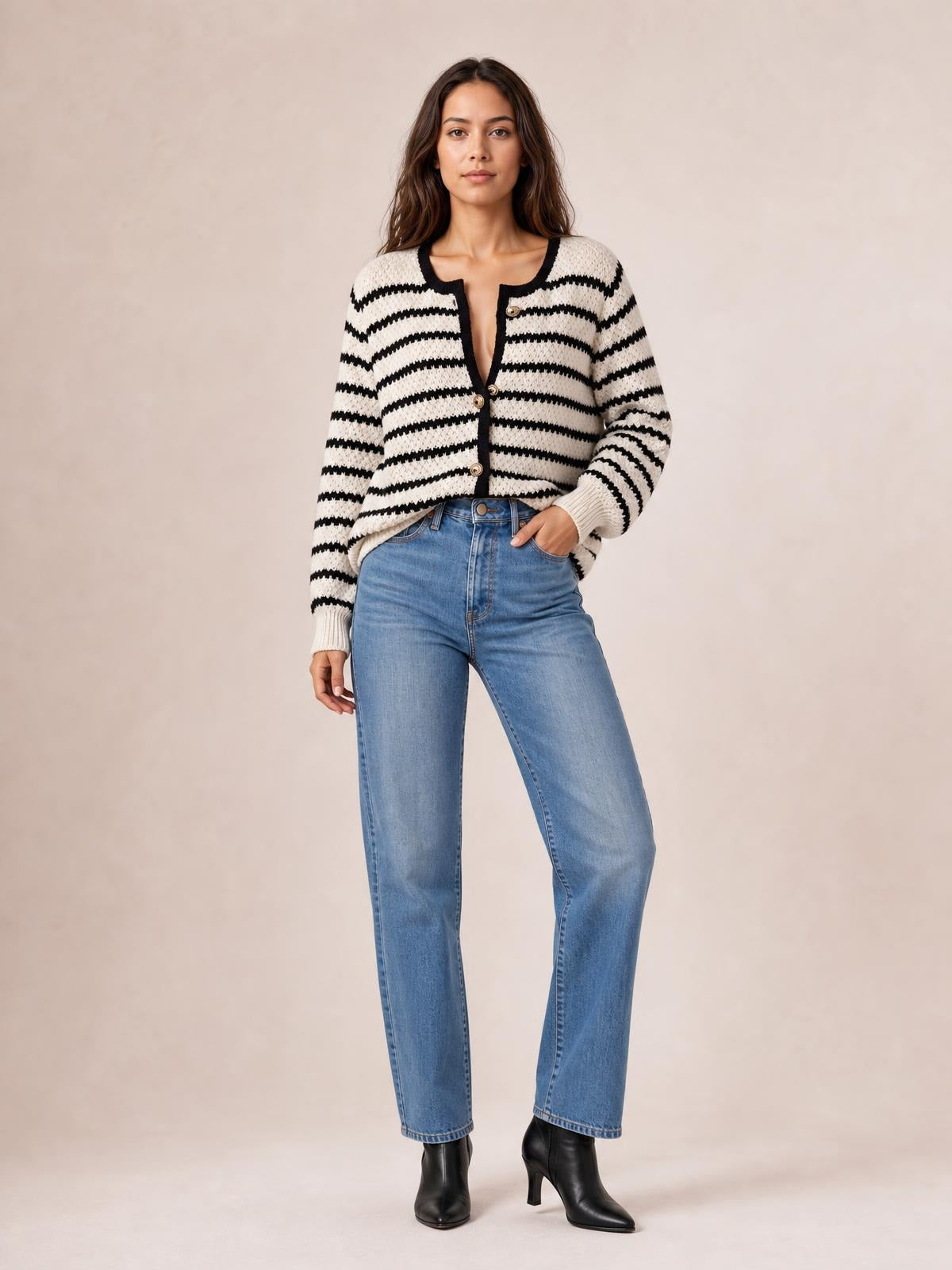 Model poses in a black-and-white striped button-up long sleeve cardigan with contrast trim, round neckline, front buttons, and a relaxed cropped silhouette.