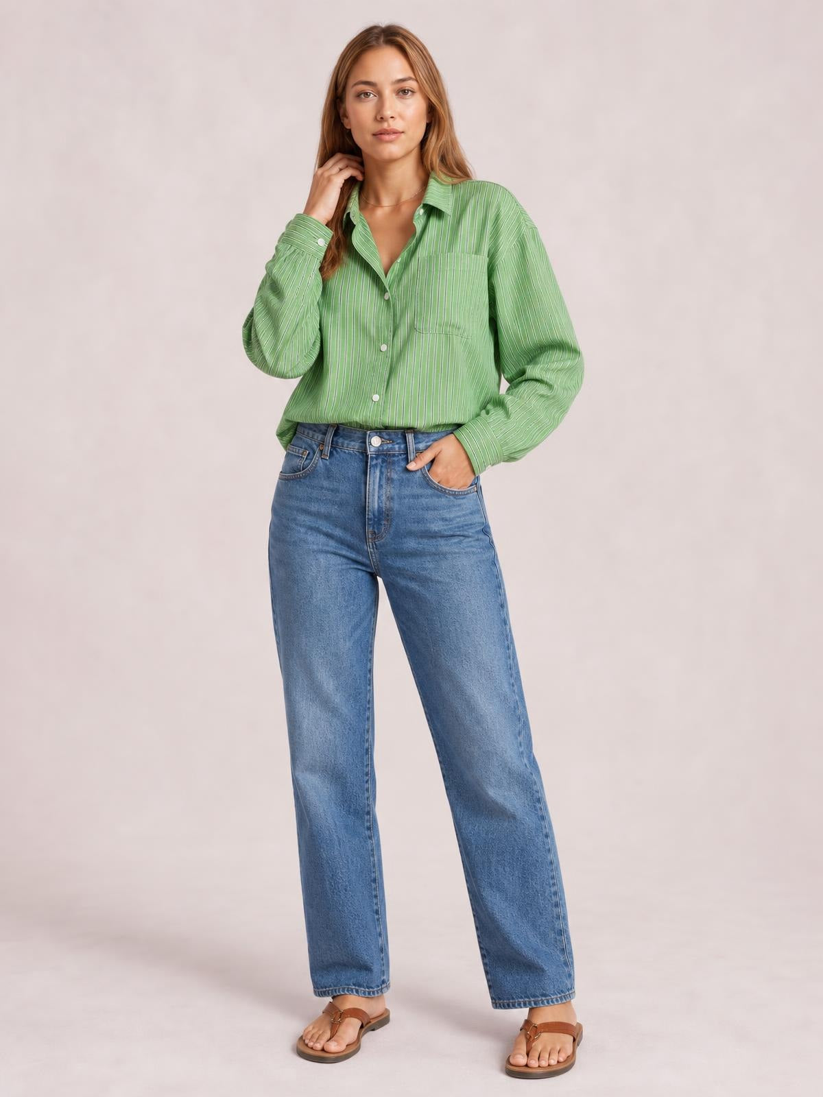 Model wears a green striped button-up long-sleeve shirt with a collared neckline, front buttons, buttoned chest pocket, and relaxed silhouette.