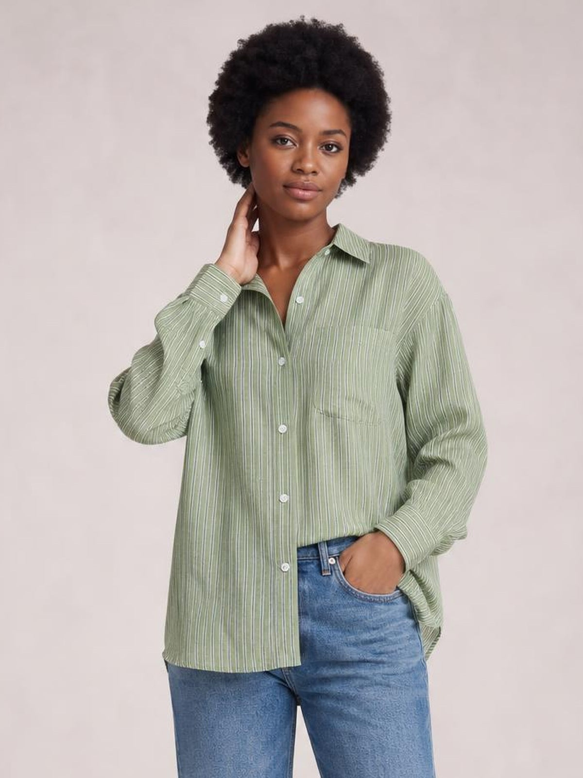 Model wearing a sage green striped button-up long sleeve shirt with a relaxed silhouette, pointed collar, buttoned cuffs, and chest pockets.