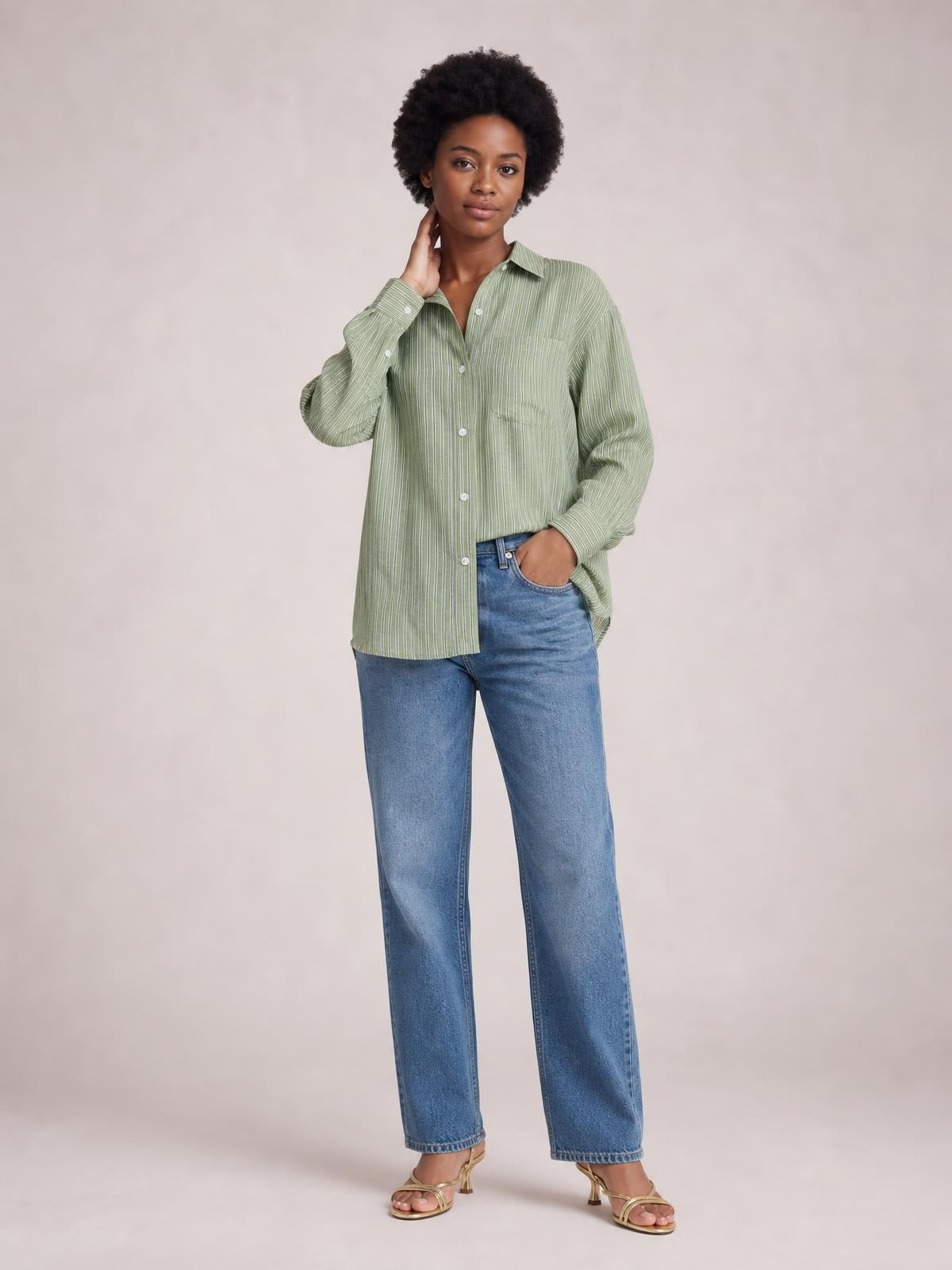 Model wears a sage green striped button-up long sleeve shirt with a relaxed silhouette, collared neckline, front buttons, and a buttoned chest pocket.