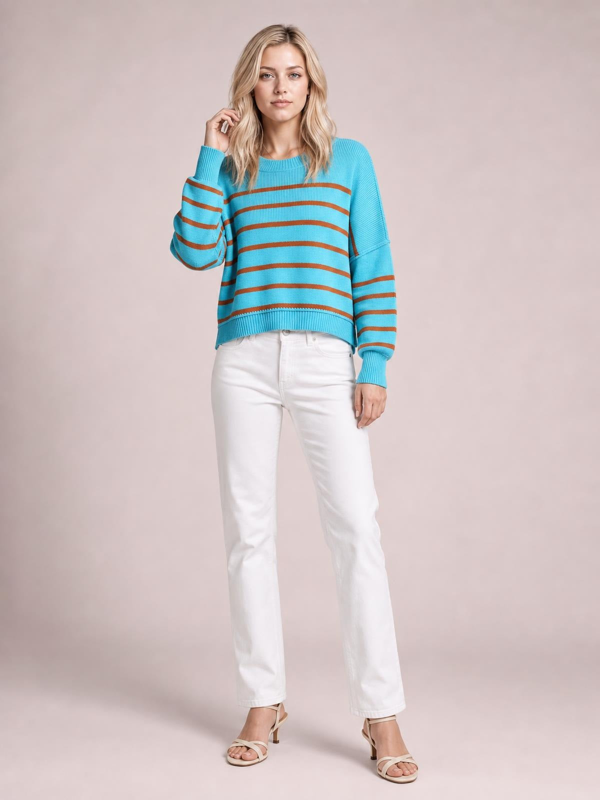 Model poses in a turquoise and brown striped dropped-shoulder round-neck pullover sweater with a relaxed silhouette, ribbed trim, and lantern sleeves.