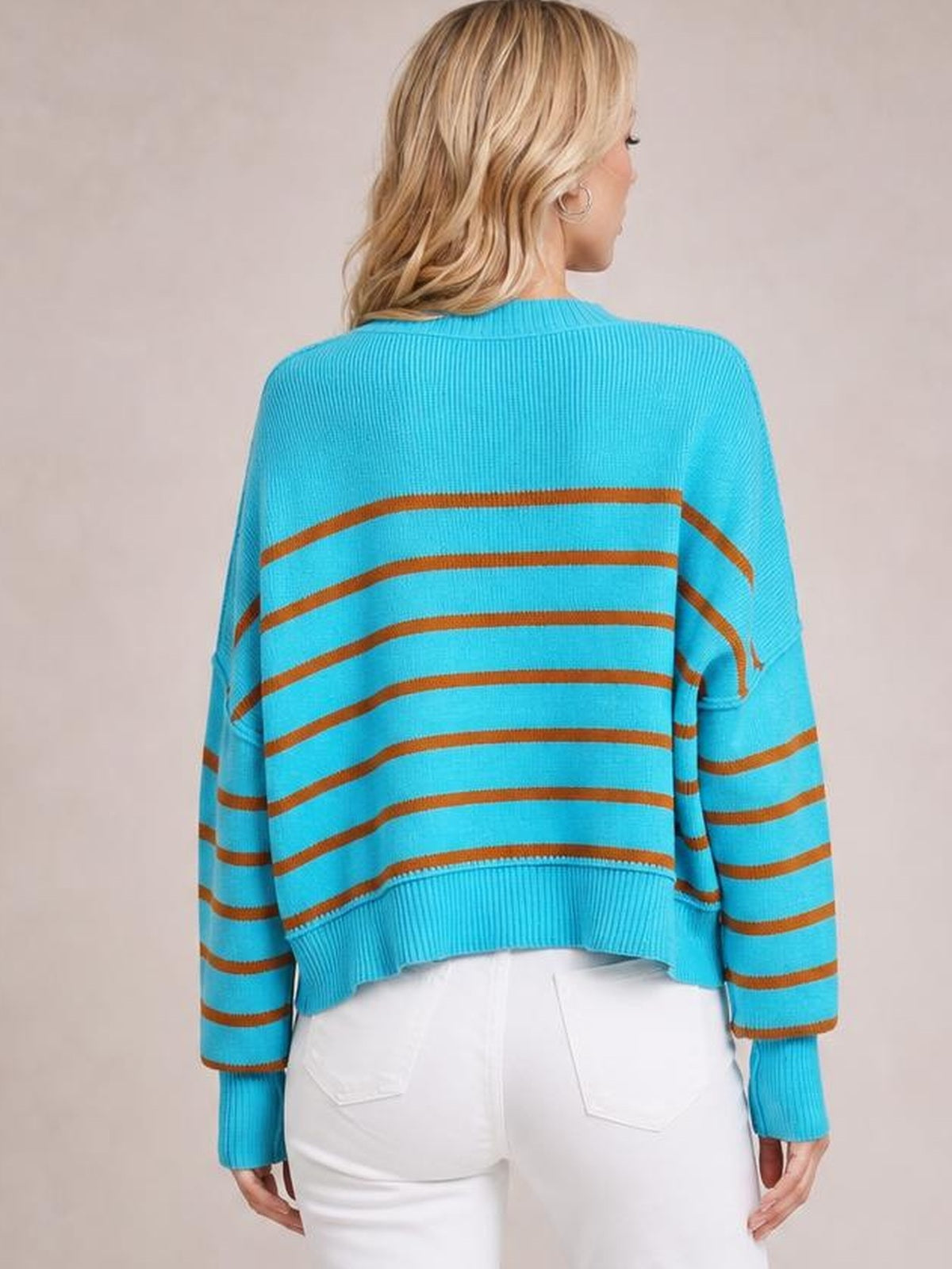 Back view of a model wearing a turquoise striped pullover sweater with a dropped shoulder, long lantern sleeves, ribbed cuffs and hem, and a regular silhouette.