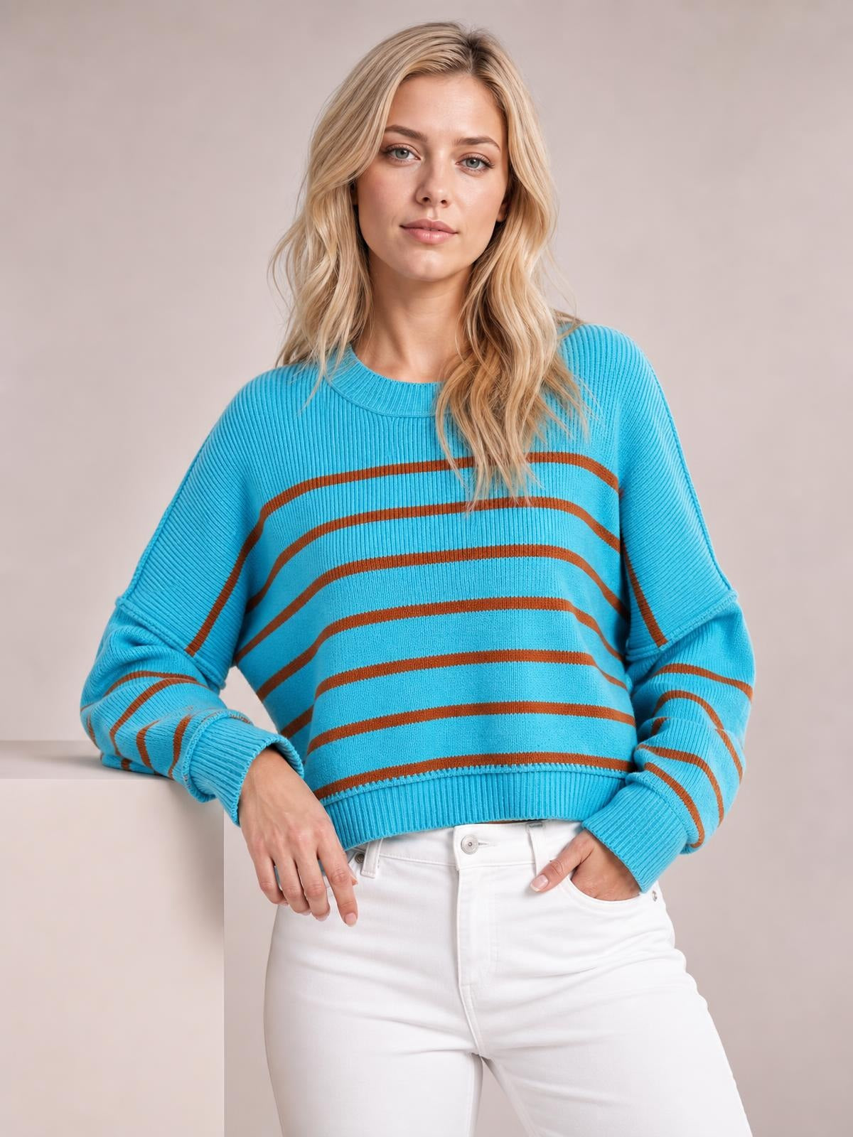 A model poses in a turquoise striped pullover sweater with a round neck, dropped shoulders, long lantern sleeves, and a relaxed regular silhouette with ribbed cuffs and hem.