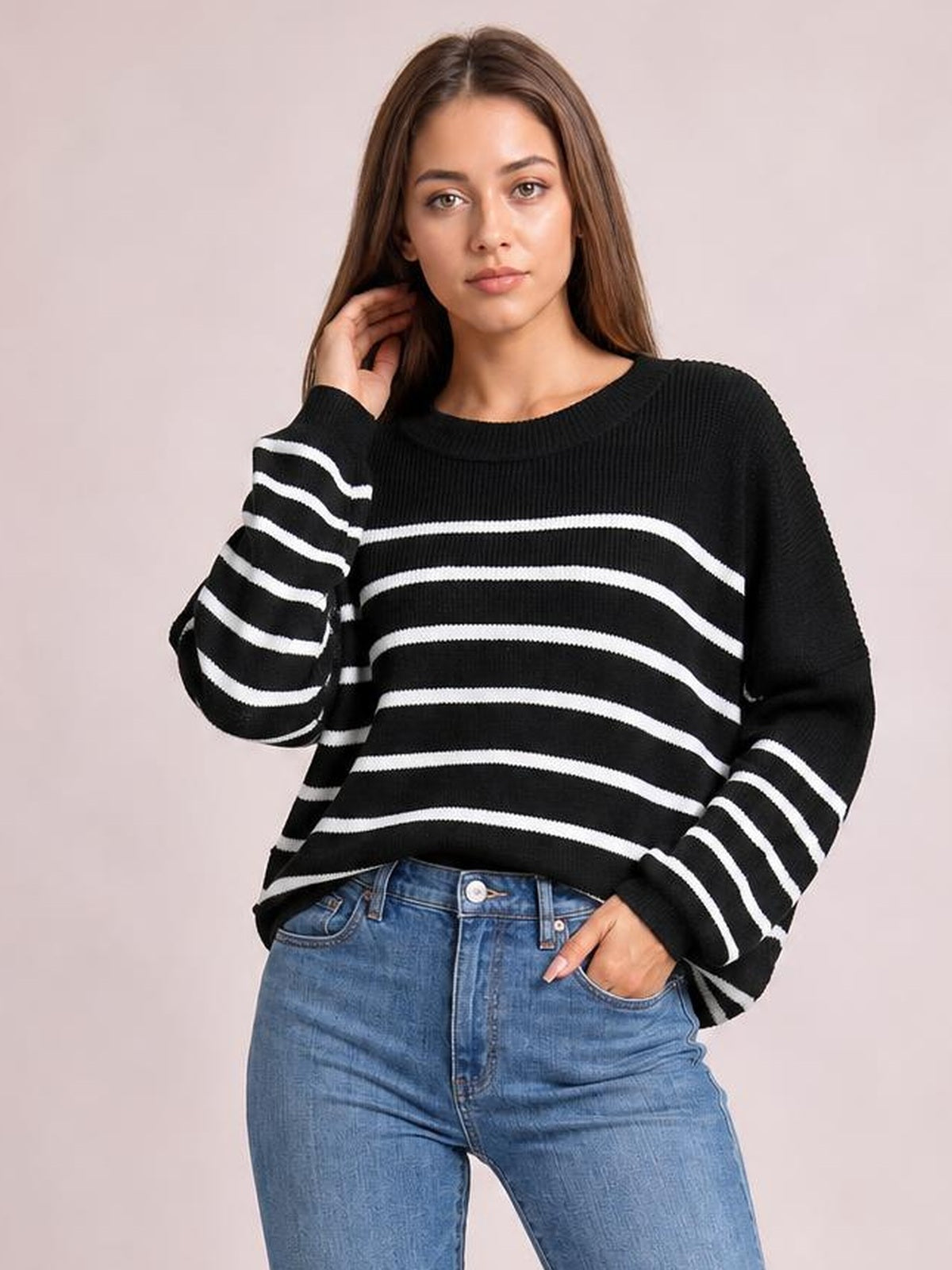 Model poses in a black striped dropped-shoulder round-neck pullover sweater with long lantern sleeves and a relaxed regular-length silhouette.