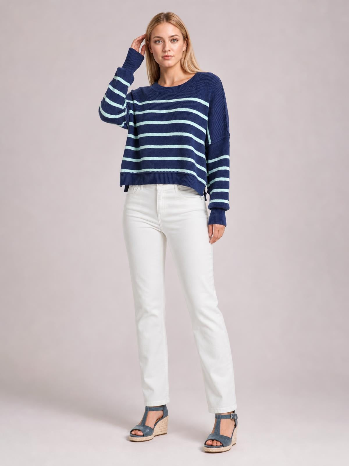 Model poses in a navy striped dropped-shoulder round-neck pullover sweater with long lantern sleeves, a relaxed regular-length silhouette, and ribbed cuffs and hem.