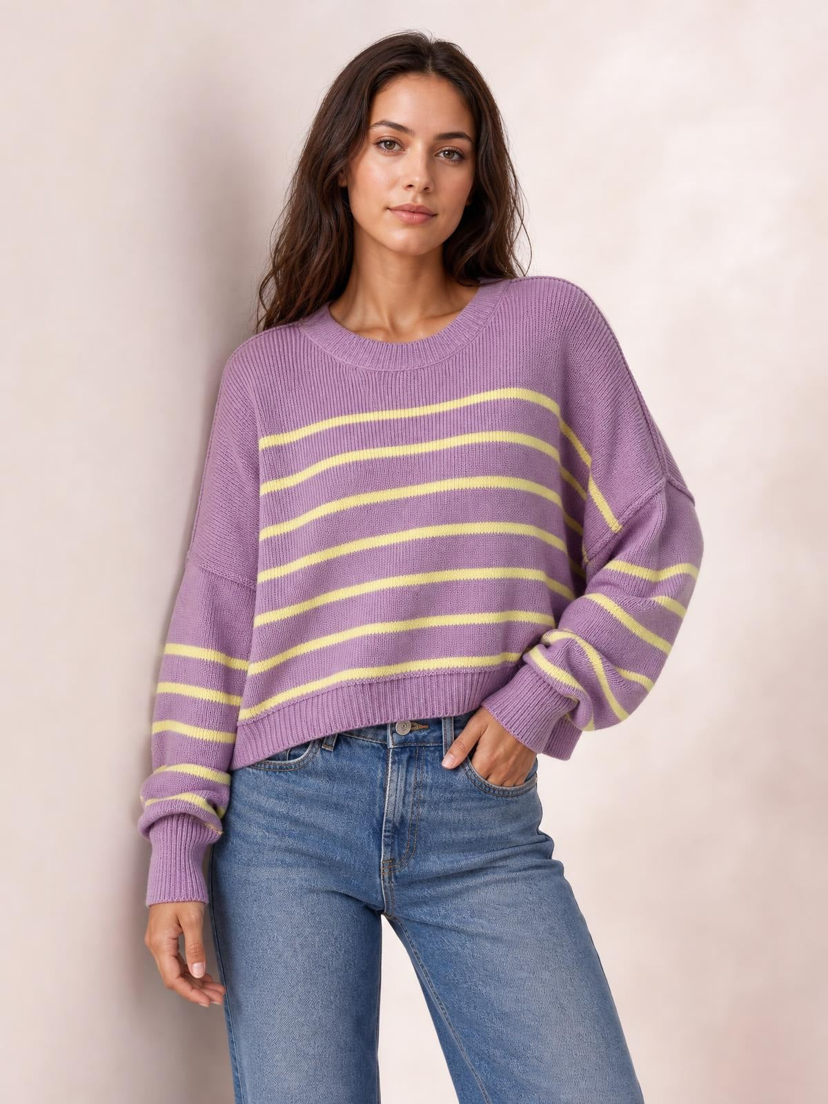 Model poses with one hand in her pocket wearing a lilac striped pullover sweater with a round neck, dropped shoulders, lantern sleeves, ribbed cuffs, and a regular silhouette.