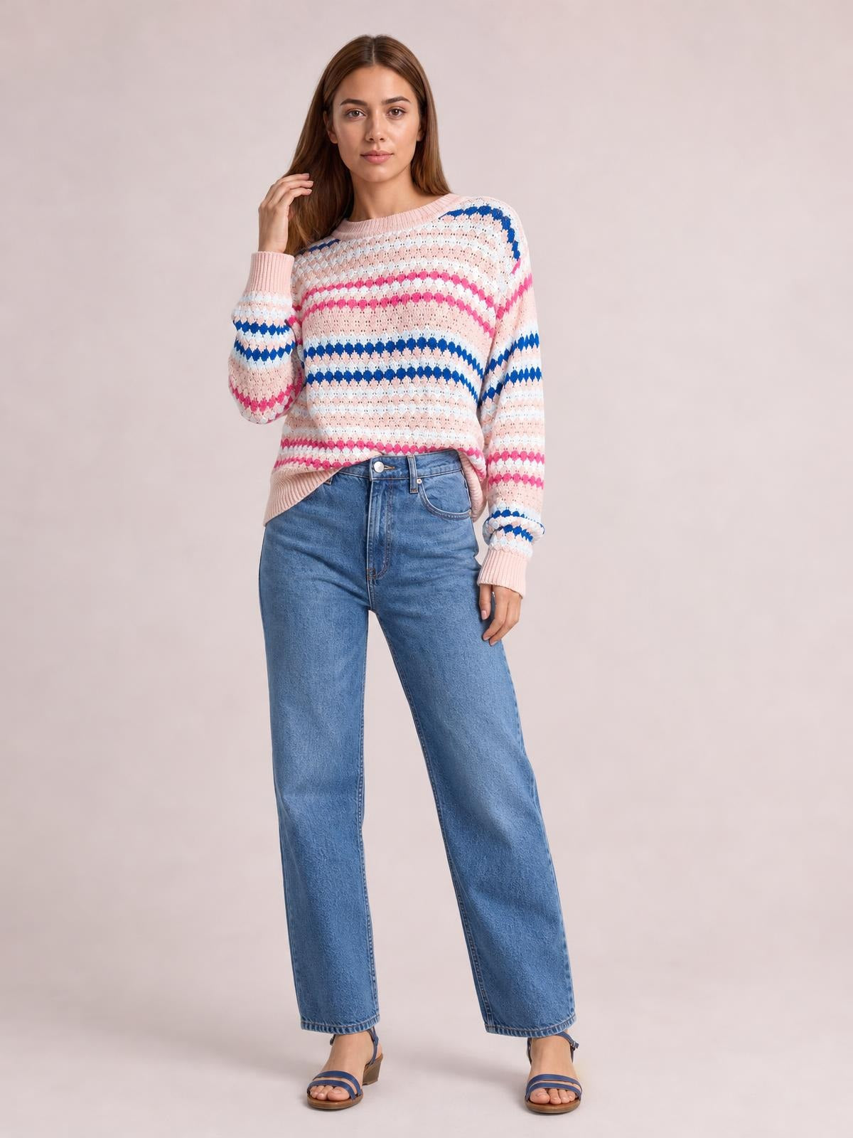 Model poses in a pink striped geometric pattern sweater with a relaxed silhouette, ribbed crew neckline, cuffs, and hem.