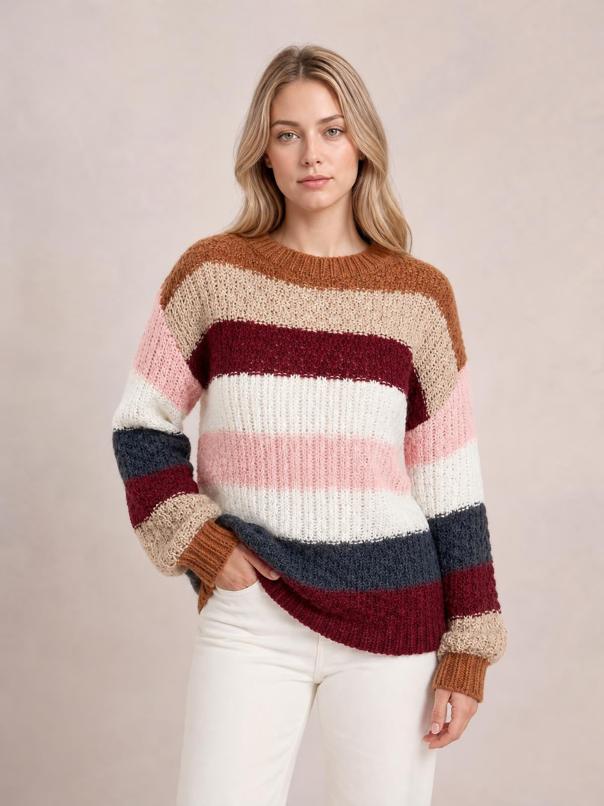 Model poses in a striped knit sweater with a round neck, dropped shoulders, long sleeves, ribbed cuffs and hem, and a relaxed silhouette.