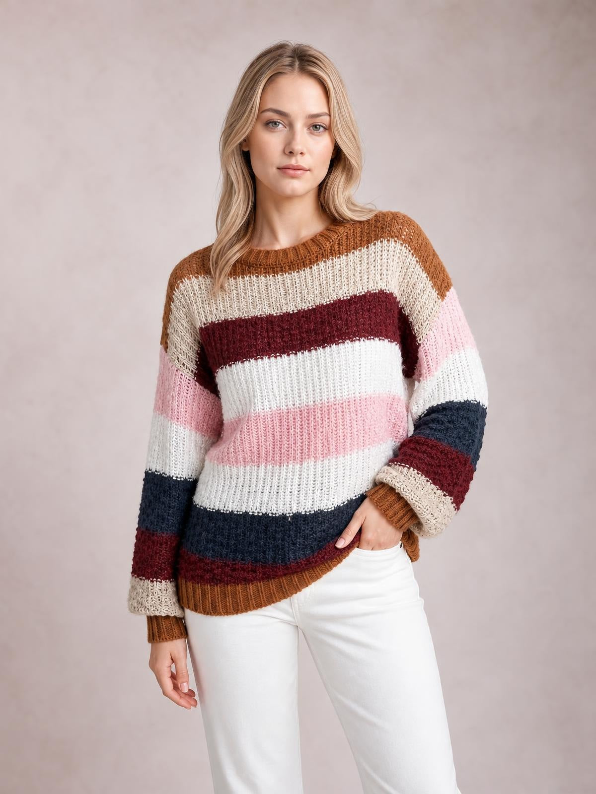 Model poses in a striped knit dropped-shoulder sweater with a round neck, relaxed silhouette, multicolor horizontal bands, and ribbed cuffs and hem.