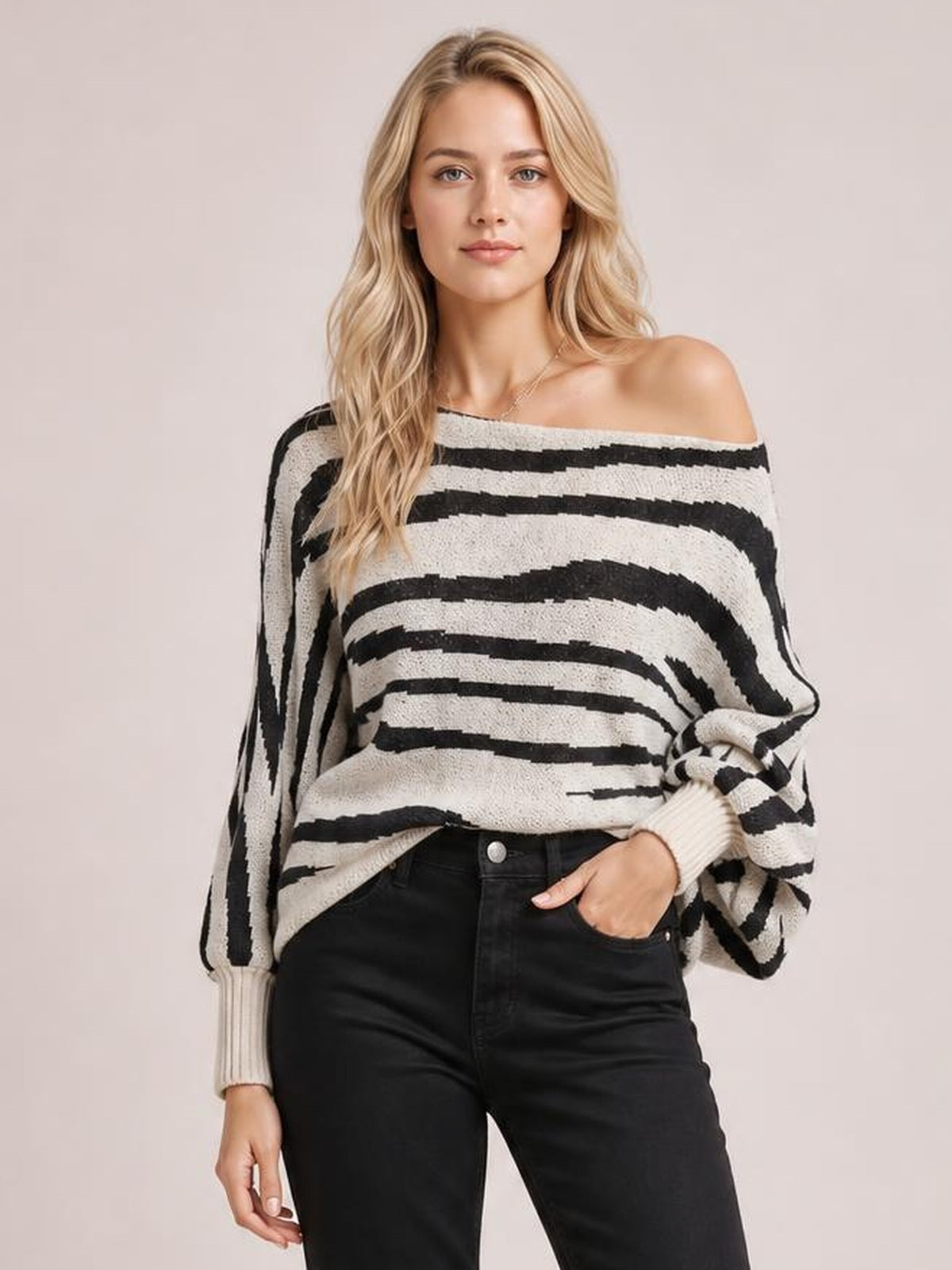 Model wearing a black and white striped sweater with an off-shoulder neckline, relaxed silhouette, ribbed cuffs, and voluminous lantern sleeves.