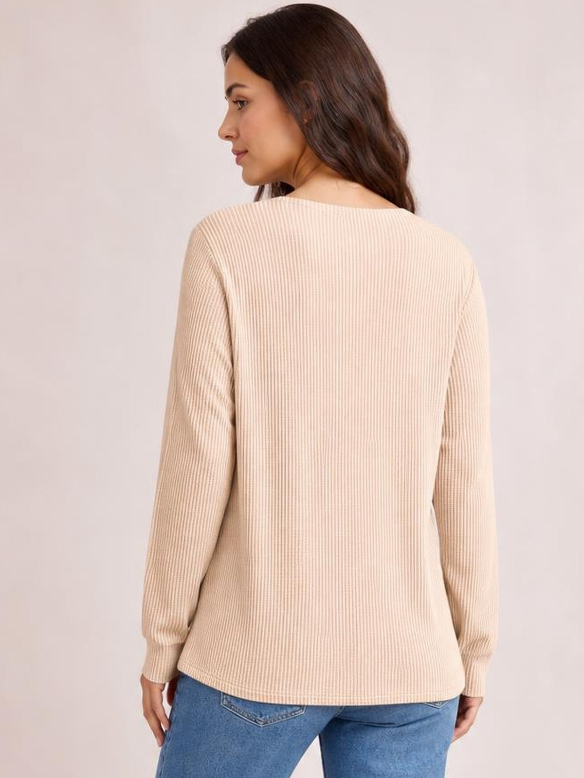 Model shown from the back wearing a beige striped long sleeve T-shirt with a relaxed straight silhouette, ribbed construction, and fitted cuffs.