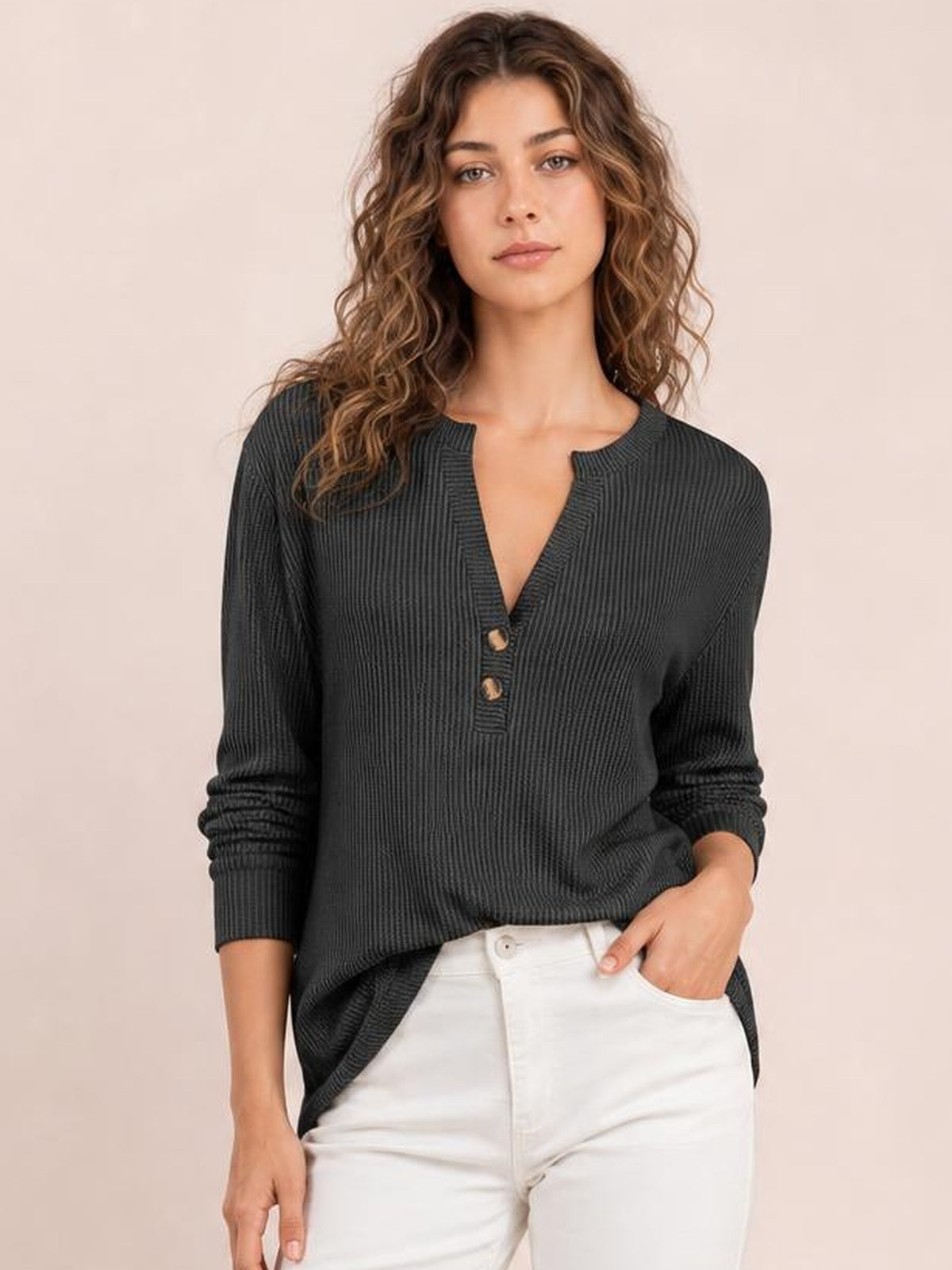 A model wears a charcoal striped long sleeve T-shirt with a notched neckline, button accents, vertical ribbed texture, and a relaxed silhouette.