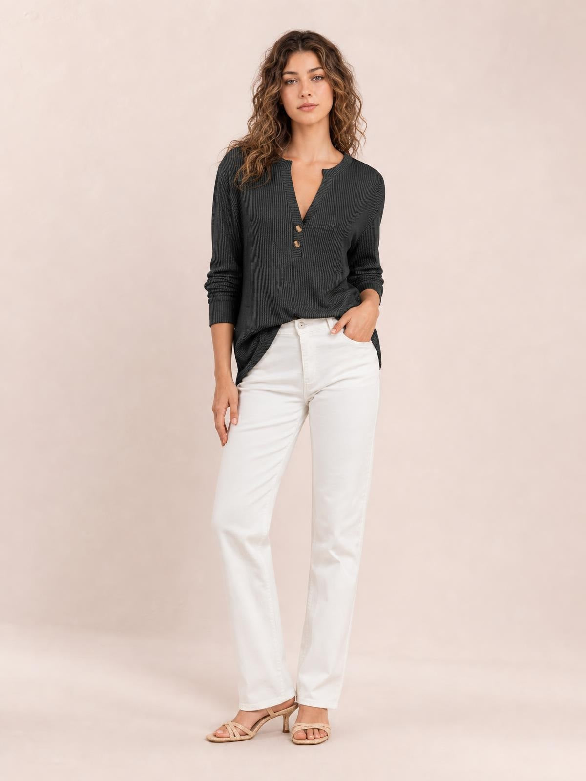 Model wears a charcoal striped notched long-sleeve T-shirt with button accents, a textured finish, relaxed silhouette, and one hand resting in her pocket.