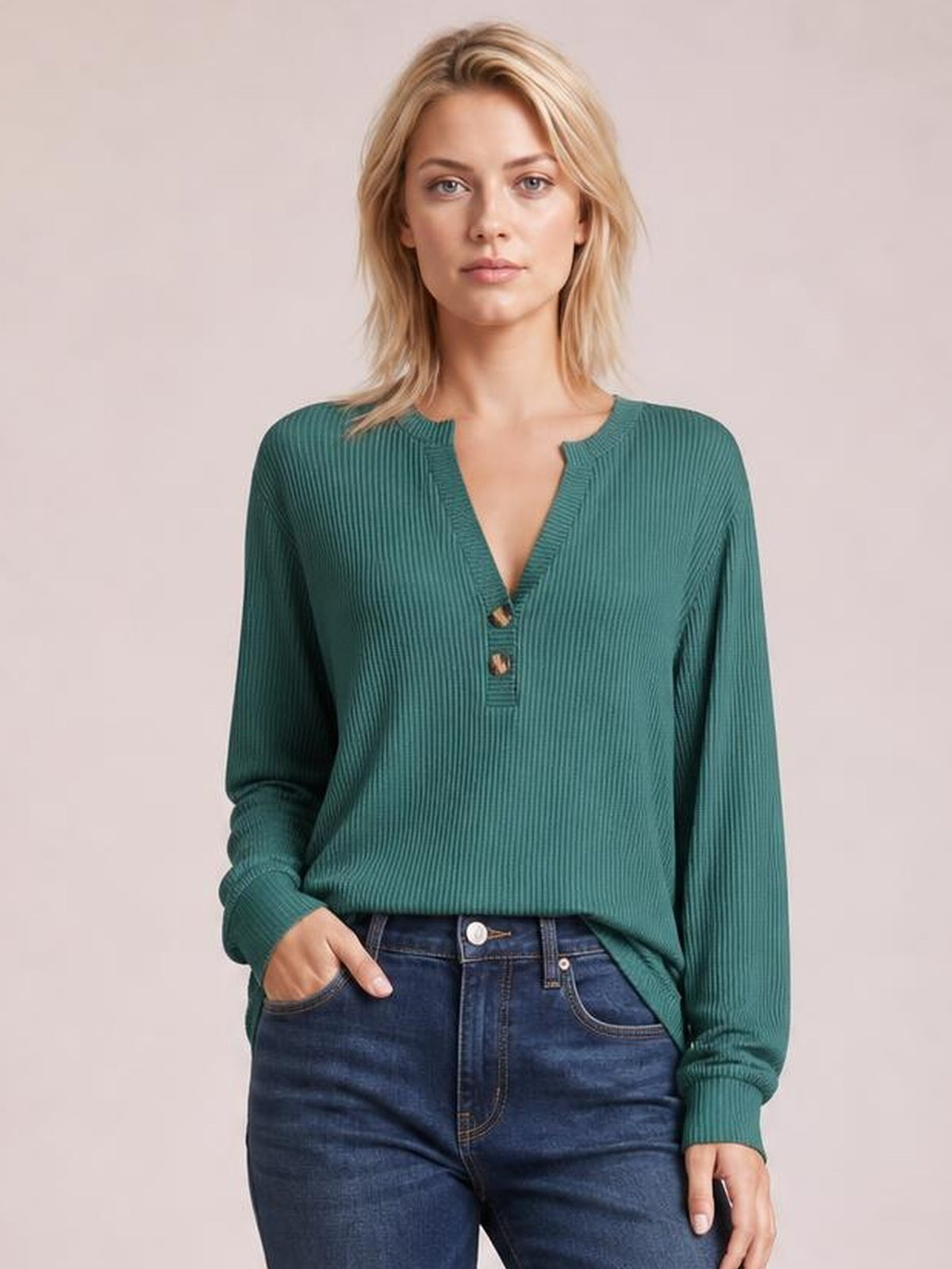 Model wearing a teal striped long sleeve T-shirt with a notched neckline, button accents, ribbed texture, and a relaxed silhouette.