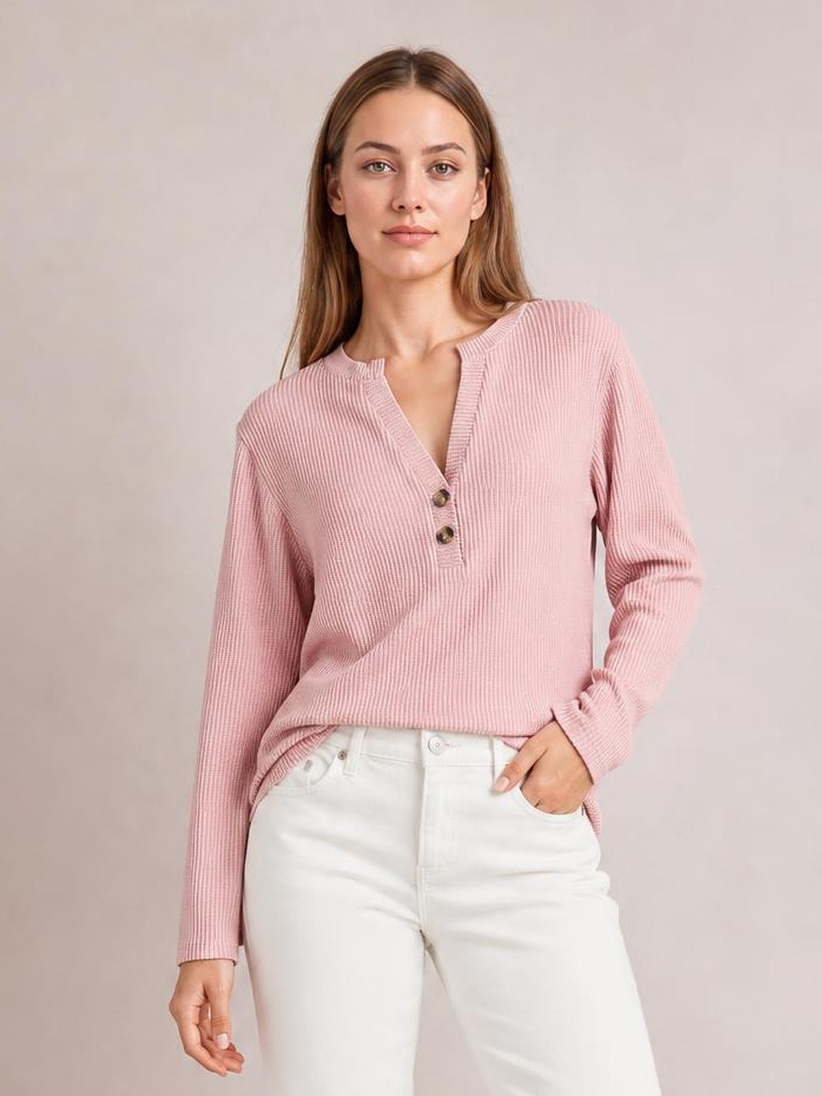 A model wears a pink striped long sleeve T-shirt with a notched neckline, two button accents, ribbed texture, and a relaxed silhouette.