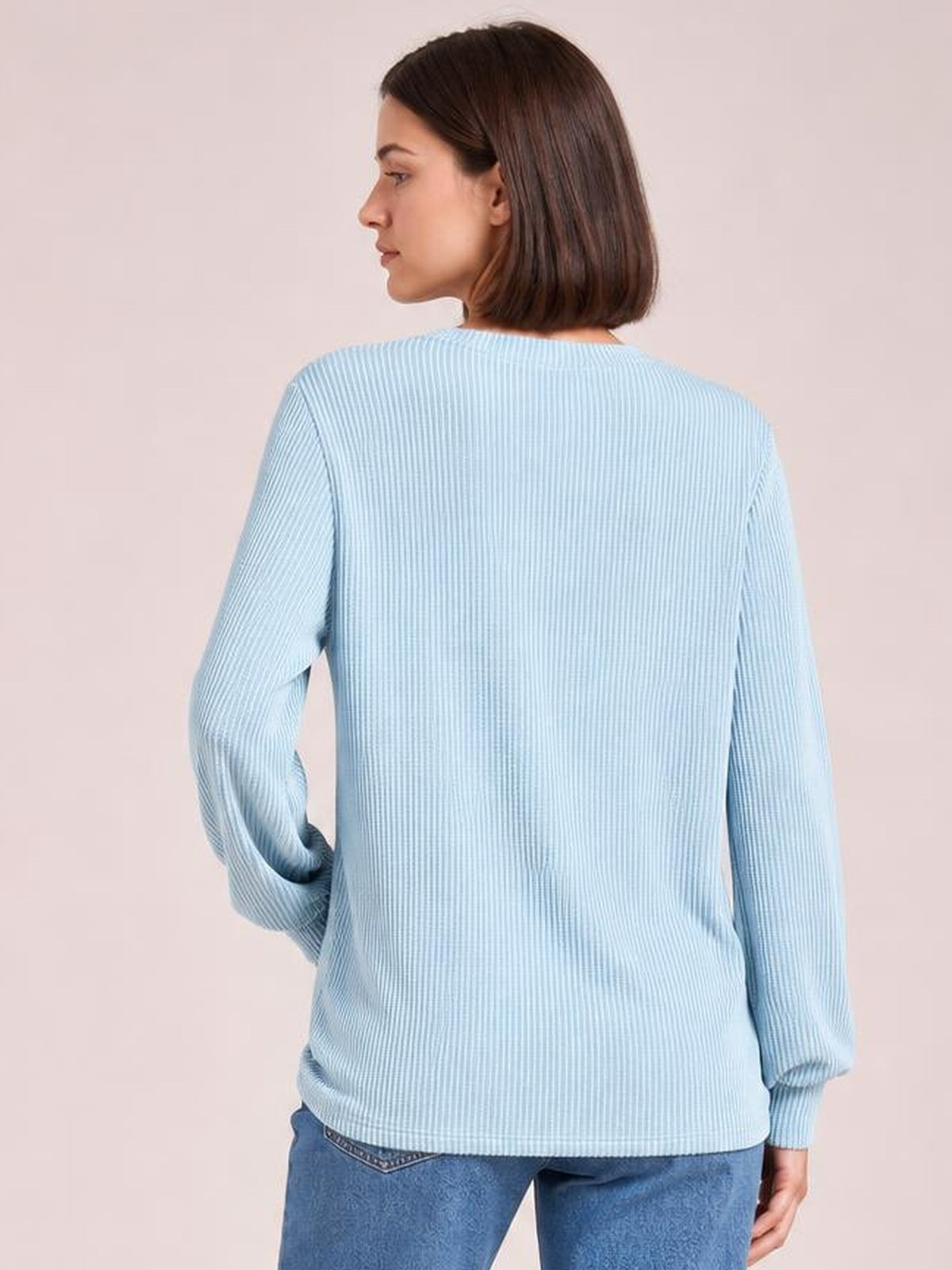 Model shown from the back in a light blue striped long sleeve T-shirt with a relaxed straight silhouette, ribbed texture, and fitted cuffs.