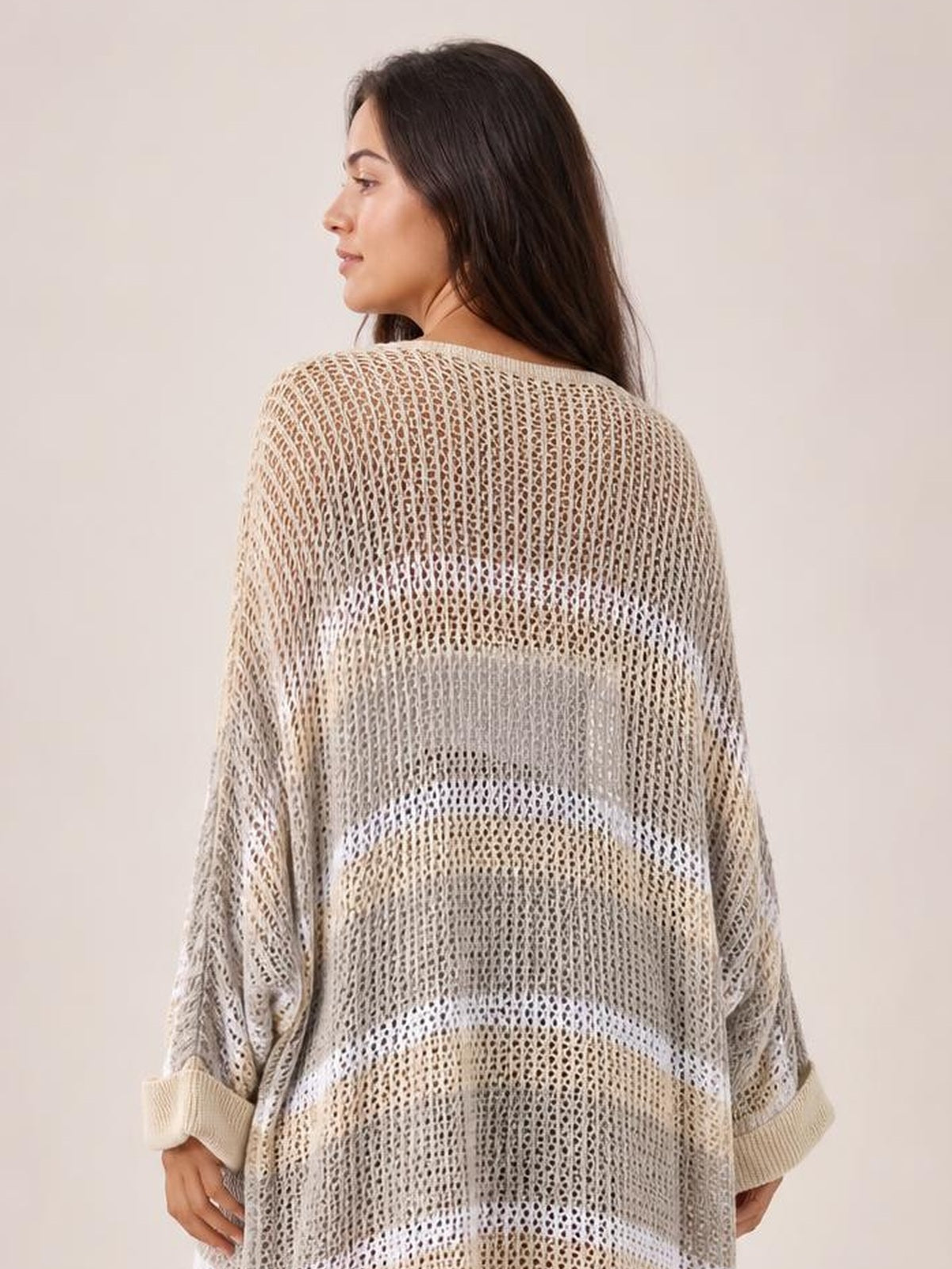 Model turned slightly away displays a sheer cream-and-beige striped duster cover-up with an open front, long sleeves, and a relaxed oversized silhouette.