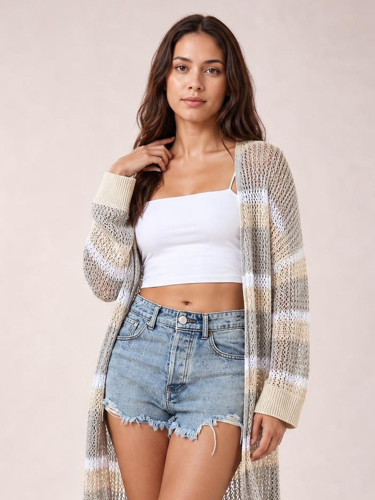 A model poses in a sheer cream and gray striped open-front duster cover-up with long sleeves, a relaxed silhouette, and visible side slits.
