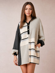 Model poses in a relaxed stance wearing a black-and-ivory striped patchwork long sleeve mini dress with a loose silhouette, button front, and contrasting stripe directions.