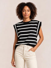 Model wearing a black and white striped round neck cap sleeve T-shirt with a relaxed straight silhouette, standing with one hand in her pocket.