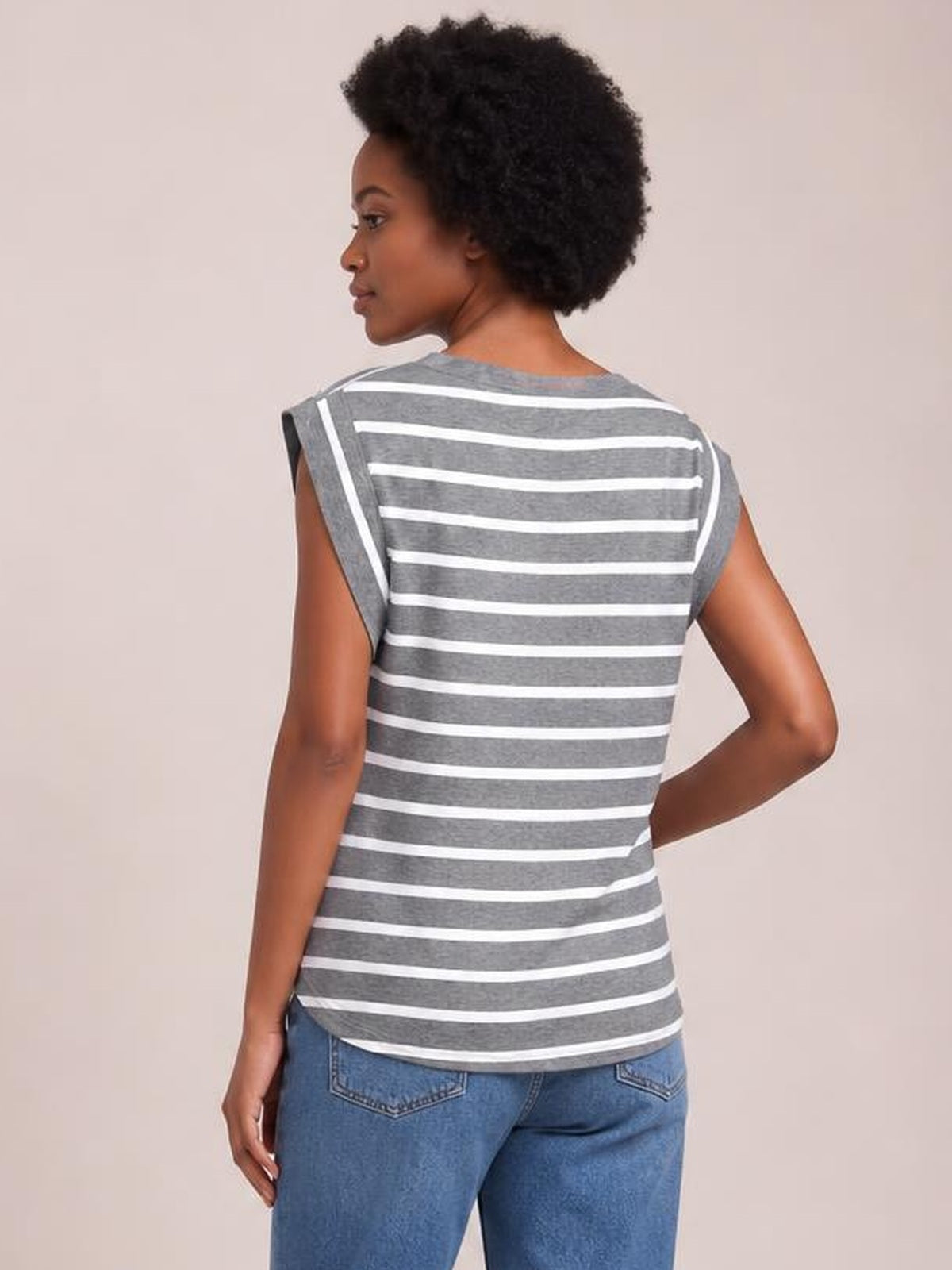 Model poses in a gray striped round neck cap sleeve T-shirt with a gently fitted silhouette and curved hem, shown from the back.