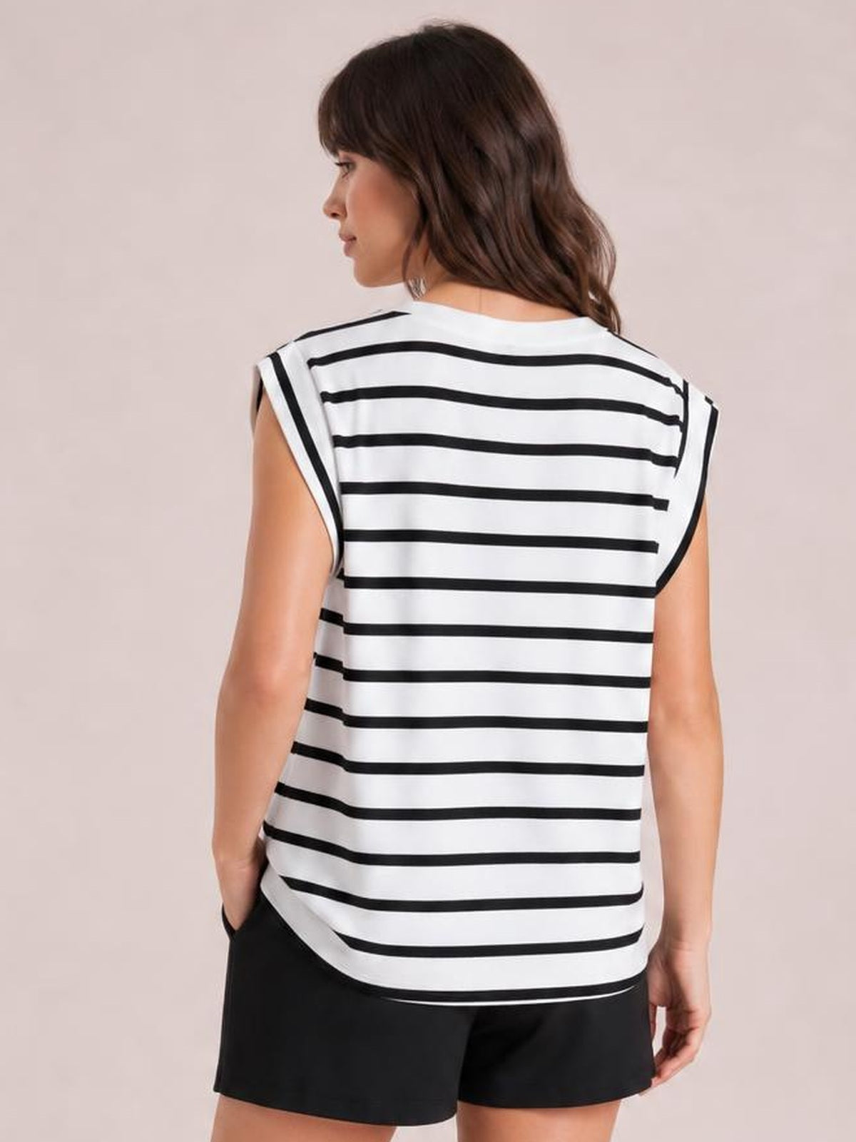 Model shown from behind wearing a white striped round neck cap sleeve T-shirt with black horizontal stripes, a relaxed silhouette, and curved hem.