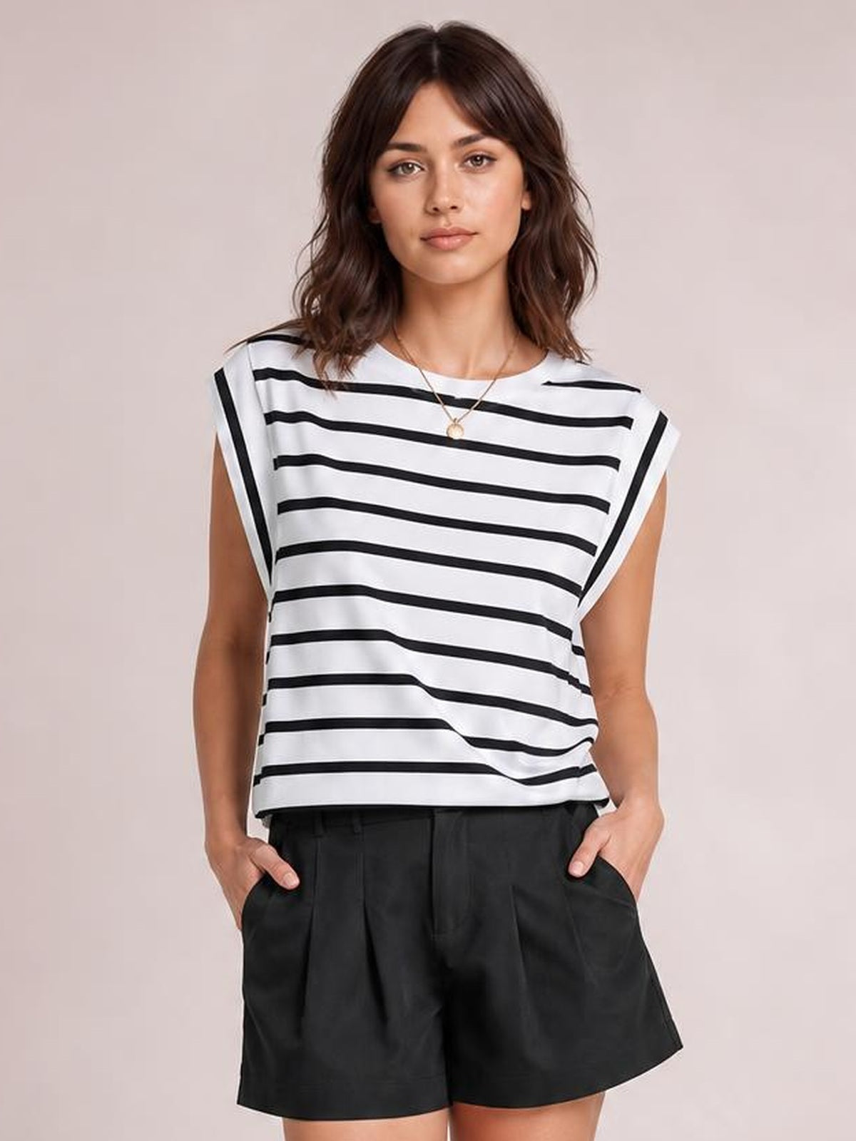 Model stands with hands in pockets wearing a white striped round neck cap sleeve T-shirt with a relaxed silhouette and contrast black horizontal stripes.