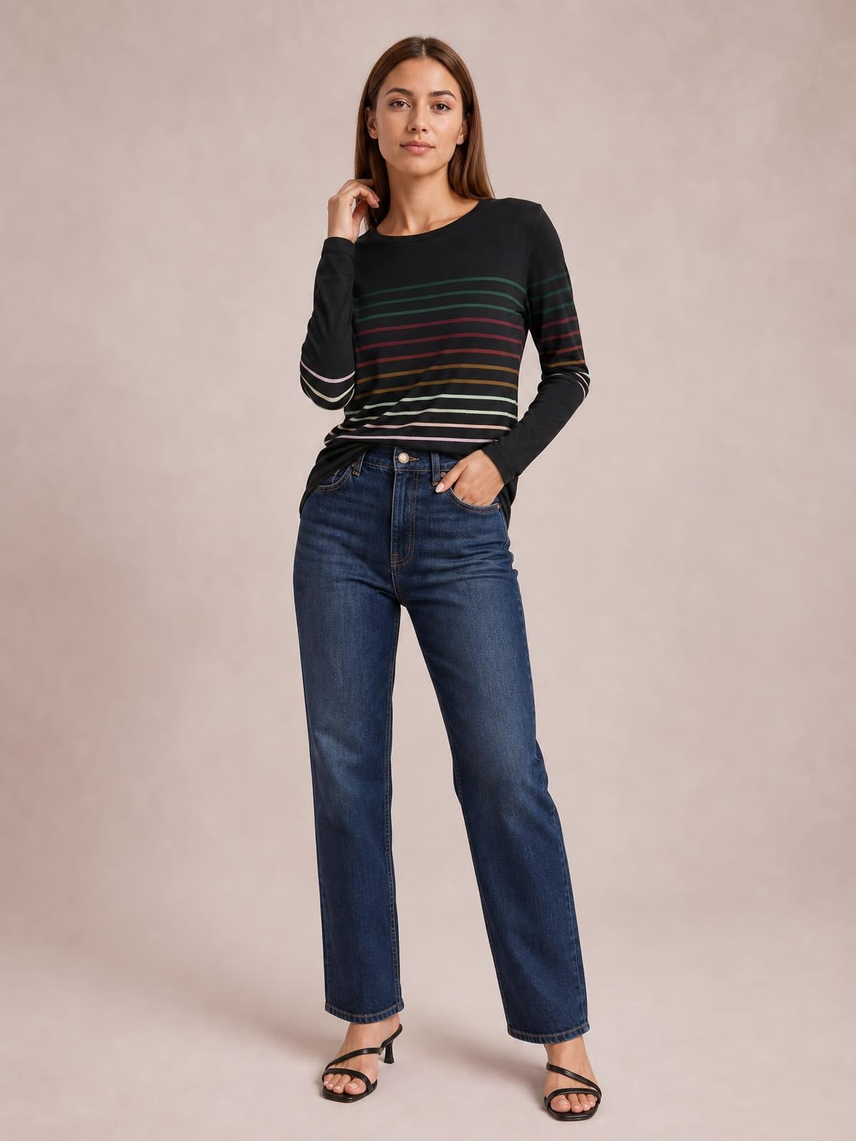 A model poses in a black striped round neck long sleeve T-shirt with colorful horizontal bands and a slim, straight silhouette.