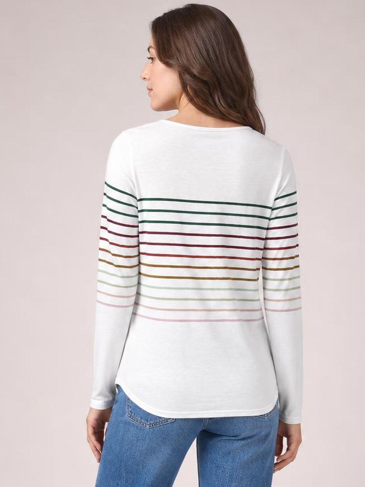 Model shown from the back wearing an opaque white striped round neck long sleeve T-shirt with a relaxed silhouette and multicolor horizontal stripes.