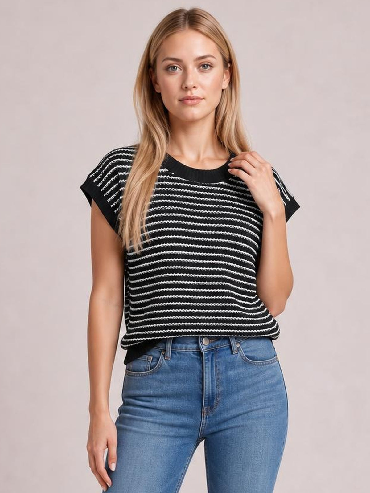 Model wears a black-and-white striped round neck short sleeve knit top with a relaxed silhouette, gently lifting one shoulder.