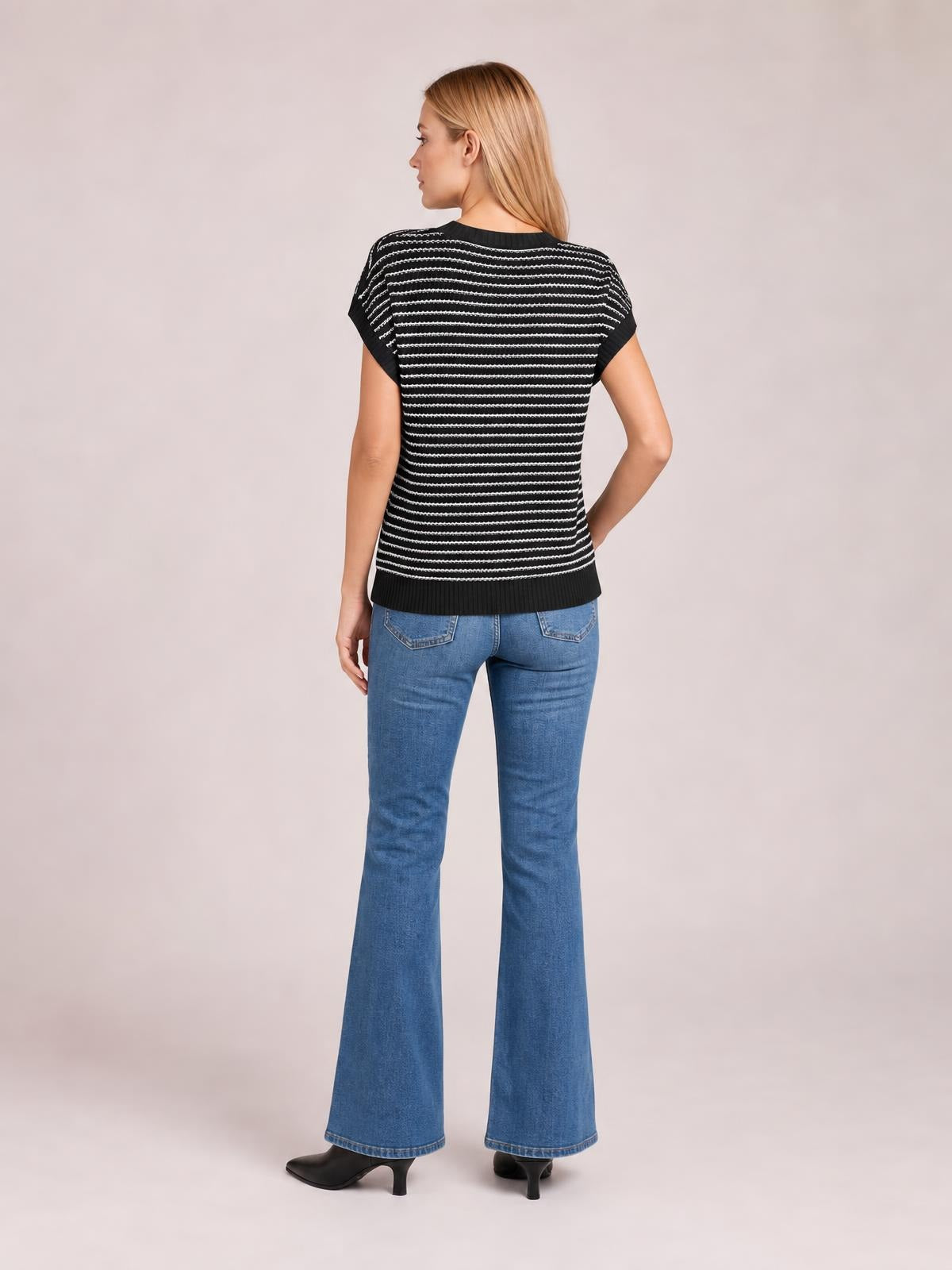 Model shown from the back wears a black-and-white striped round-neck short-sleeve knit top with a relaxed straight silhouette and ribbed hem.