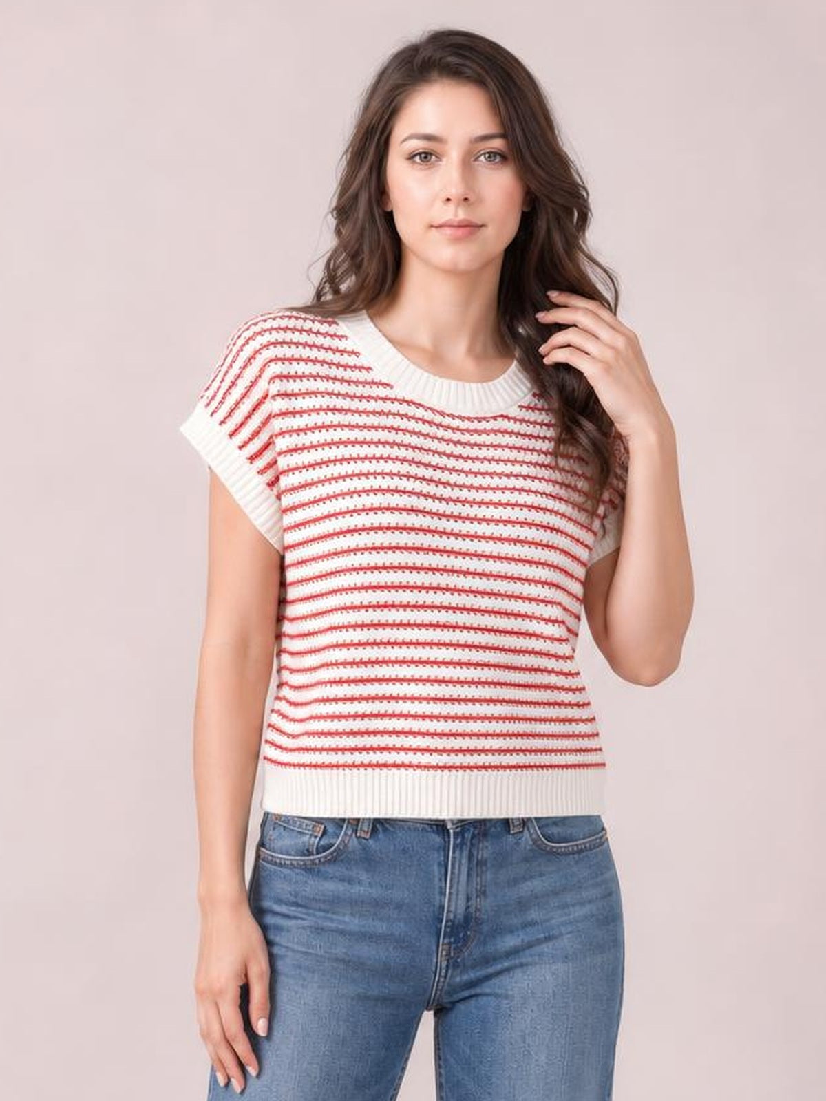 A model poses in a white knit top with red horizontal stripes, a round ribbed neck, short sleeves, and a relaxed straight silhouette.