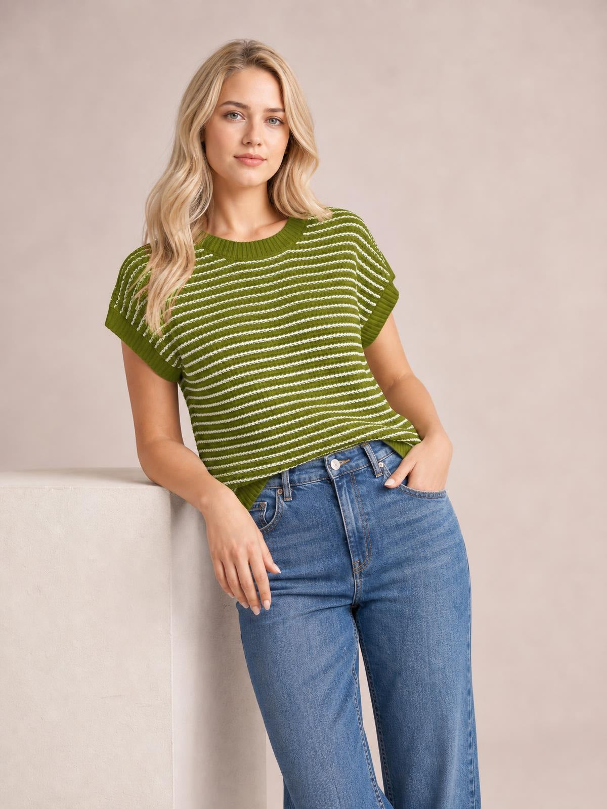 Model poses in a green striped knit top with a round neck, short sleeves, ribbed trim, and a relaxed silhouette.