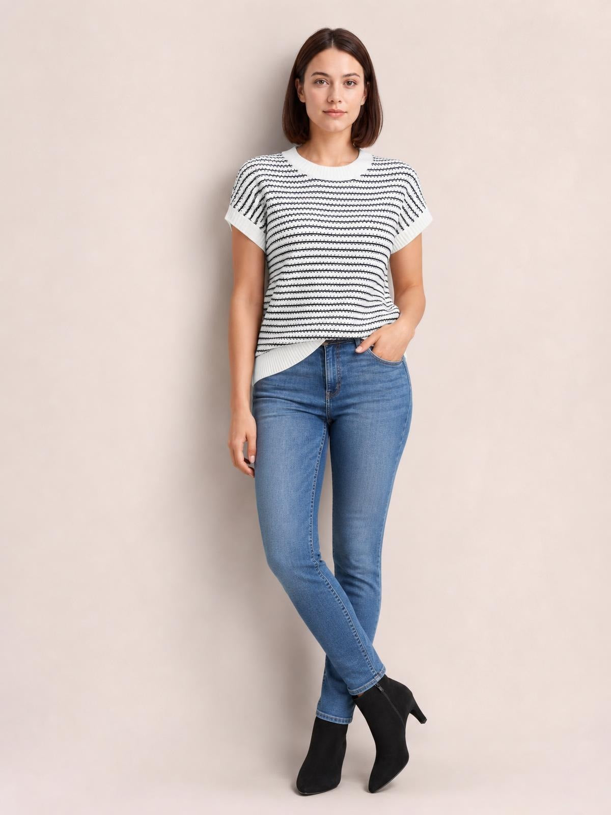 Model stands with crossed legs wearing a white striped round-neck short-sleeve knit top with contrasting ribbed trim and a relaxed silhouette.