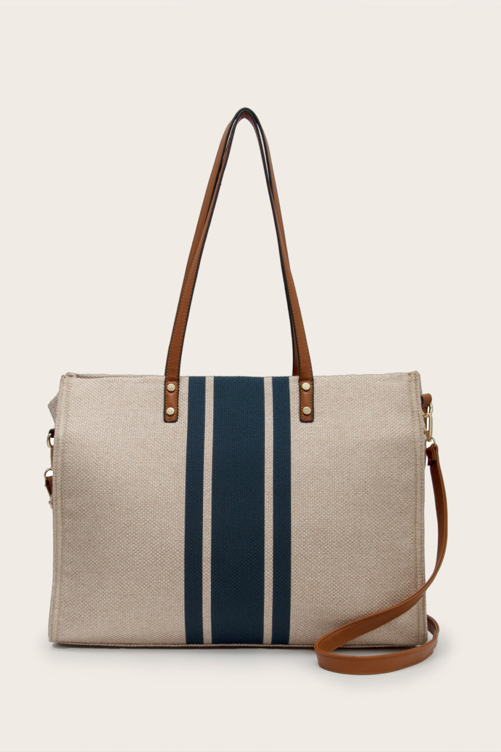 Oversize khaki striped tote bag with a woven rectangular silhouette, bold navy vertical stripes, brown top handles, and a detachable shoulder strap.