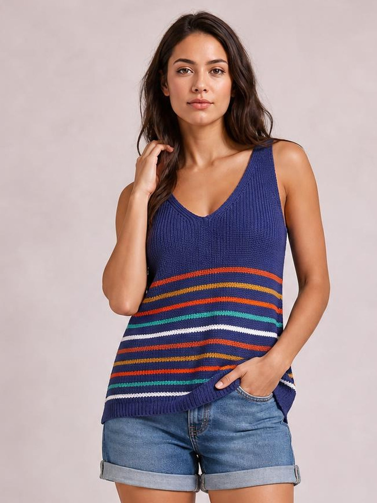 A model poses in a navy striped V-neck knit tank with wide shoulder straps, a relaxed straight silhouette, and multicolored horizontal bands.
