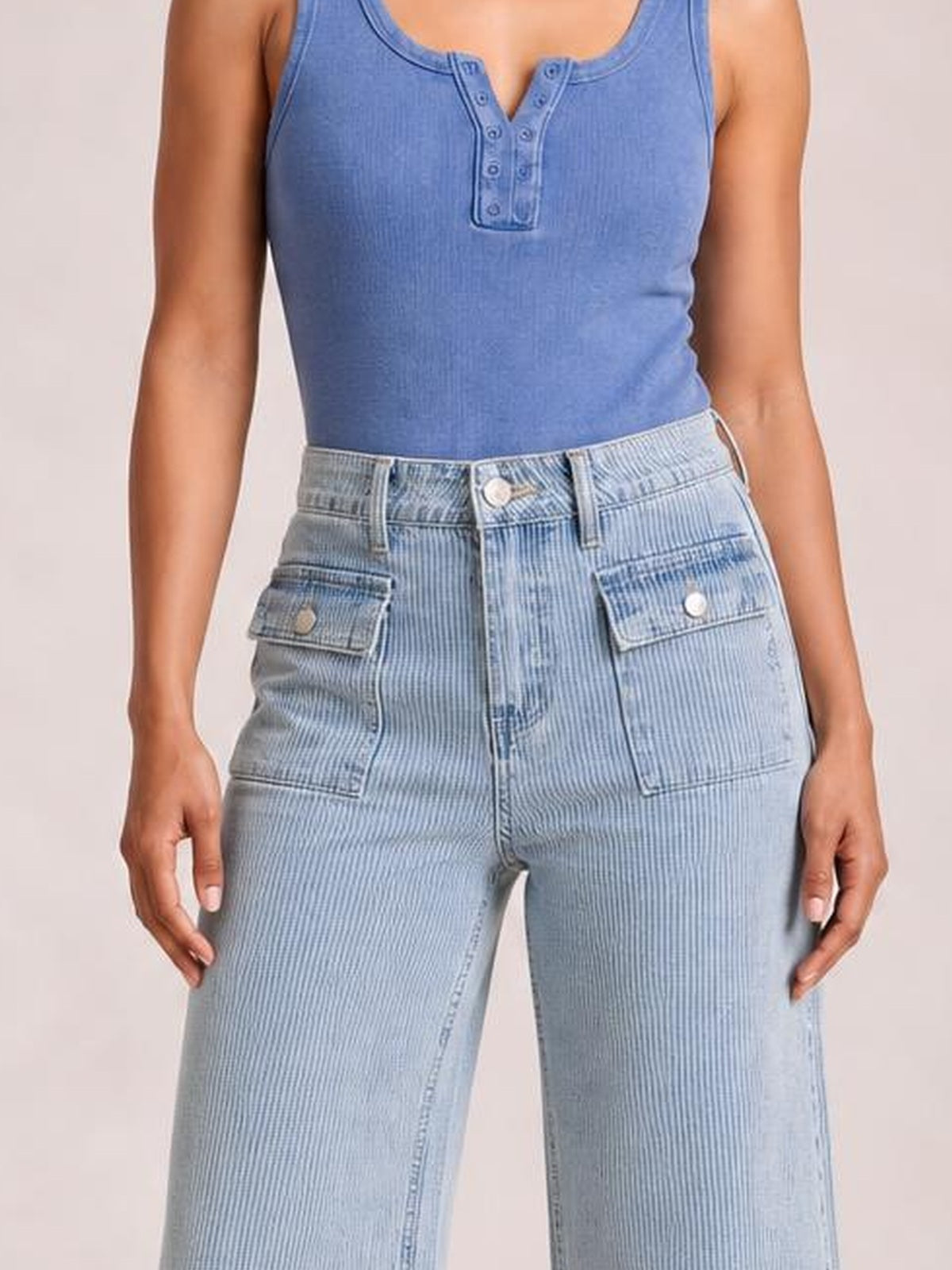 A standing model wears light blue striped wide-leg cropped jeans with a high-rise waistband, belt loops, button closure, zipper fly, and patch pockets.