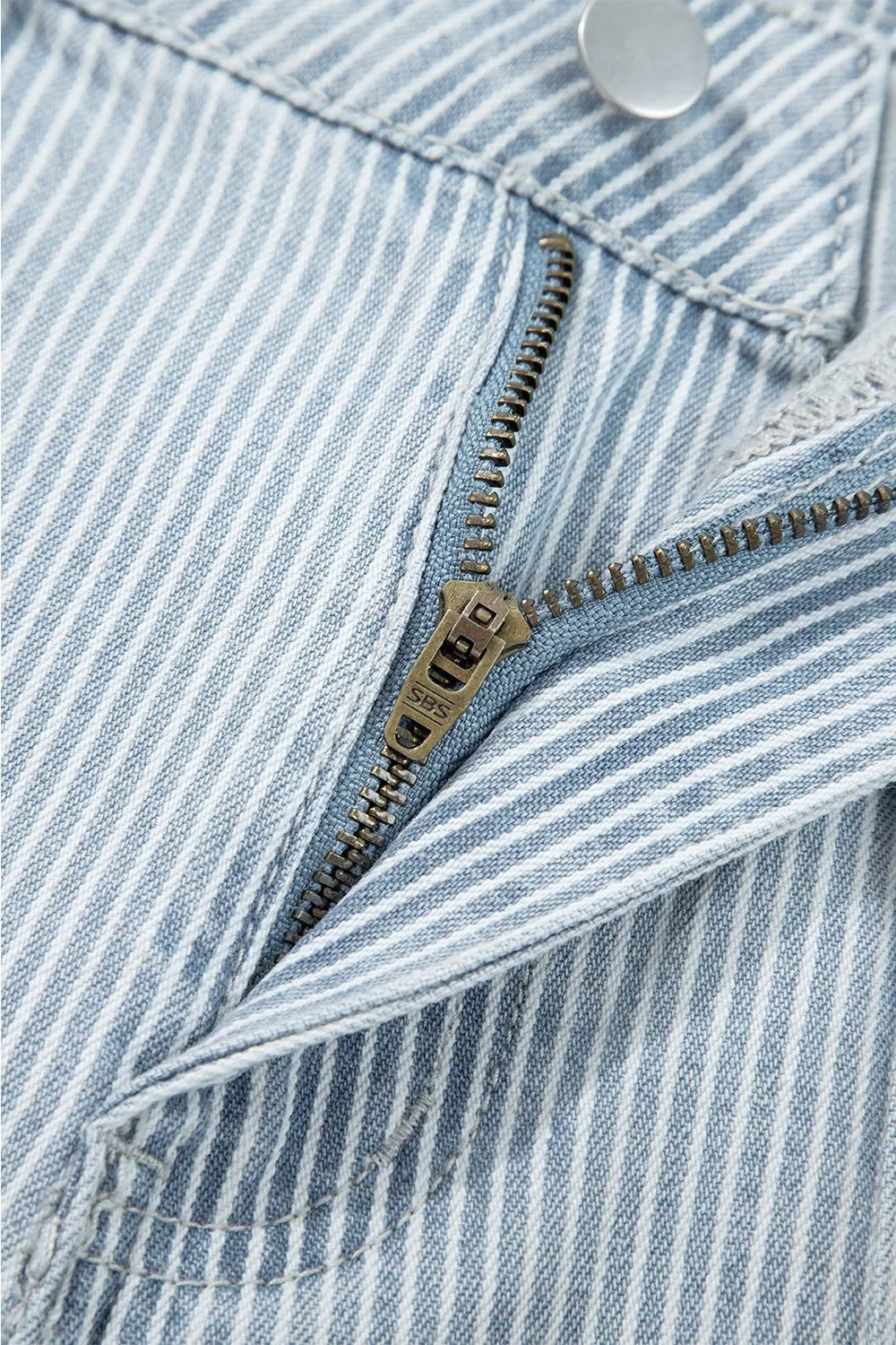 Light blue striped jeans feature white vertical pinstripes, a metal button, zip fly, and a neatly stitched pocket opening.