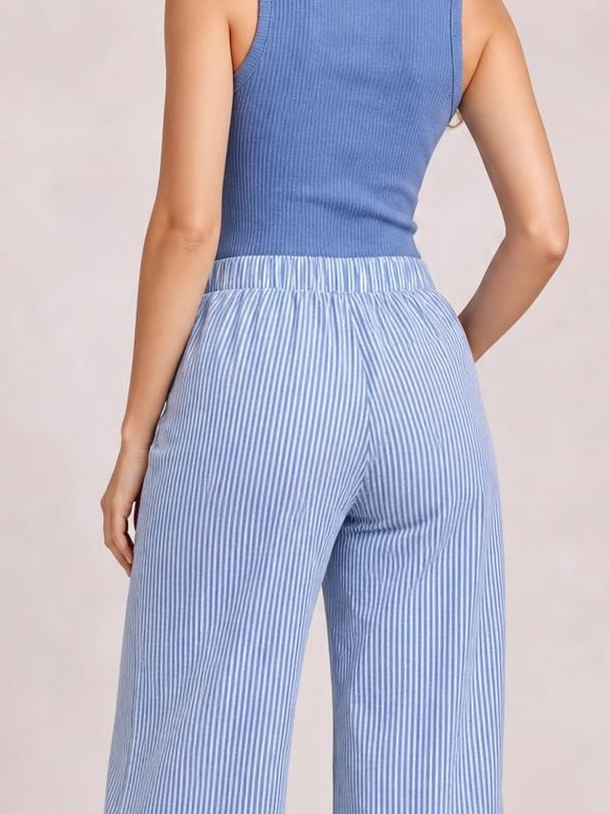 Model shown from behind wearing blue-and-white striped wide leg pants with an elastic waist, relaxed silhouette, and visible side pockets.