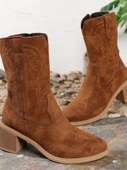 Brown suede-style western boots with mid-height block heels, pointed toes, stitched decorative panels, and pull tabs for a structured cowboy silhouette.