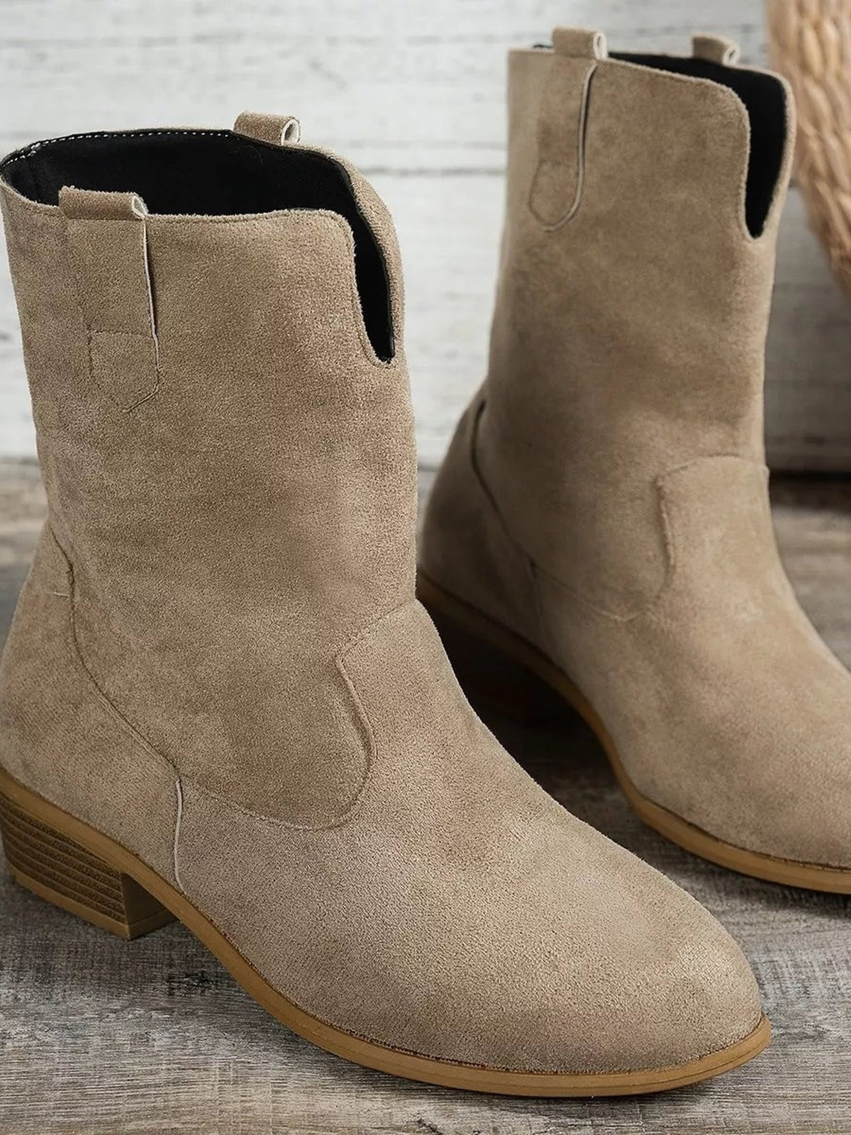 Taupe suede-look western ankle boots feature rounded toes, pull tabs, curved side stitching, and mid-height block heels.