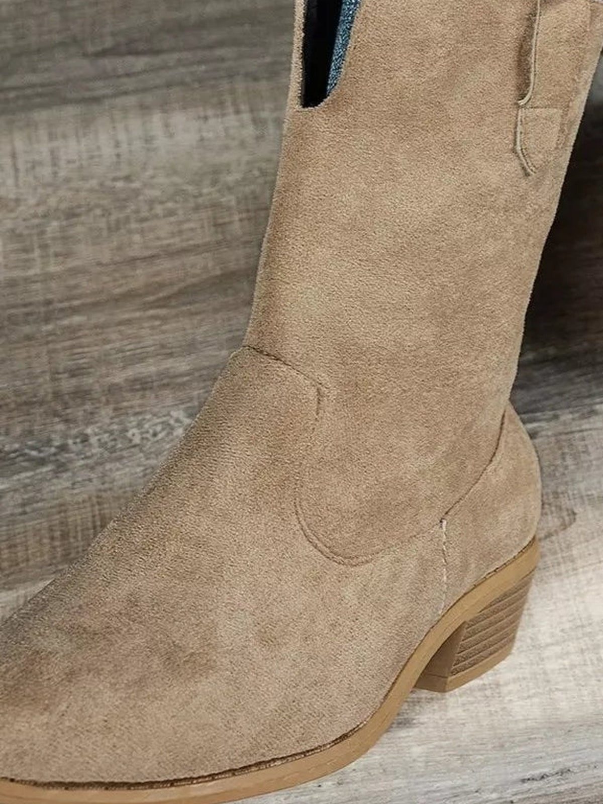 Tan suede western ankle boot with a pointed toe, stitched panel detailing, side zipper, and a stacked mid-height block heel.