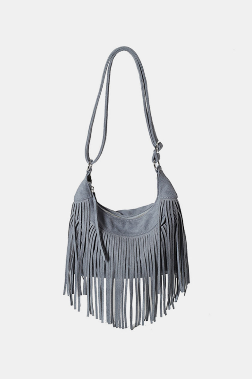 A small gray suede shoulder bag features a softly curved silhouette, adjustable strap, zippered top, and long layered fringe along the sides and bottom.
