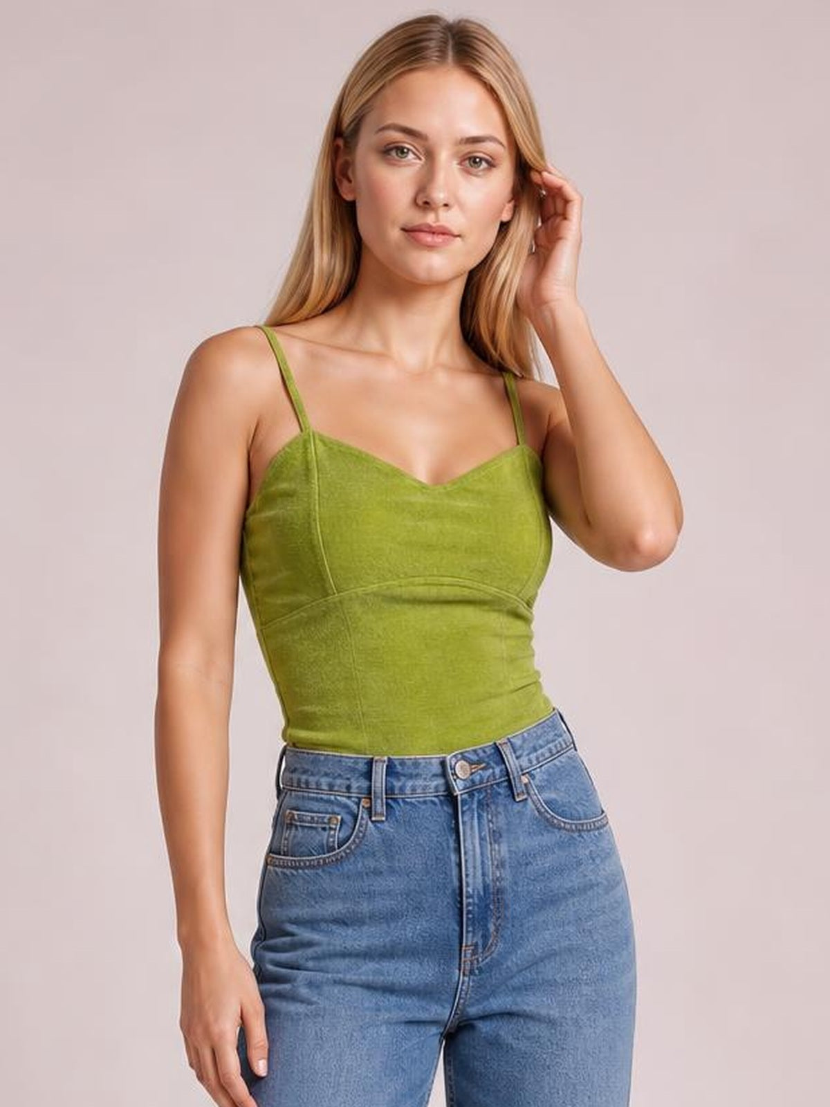 Model wearing a green sweetheart-neck cropped cami with thin straps, fitted seamed silhouette, and a slightly stretchy opaque fabric.