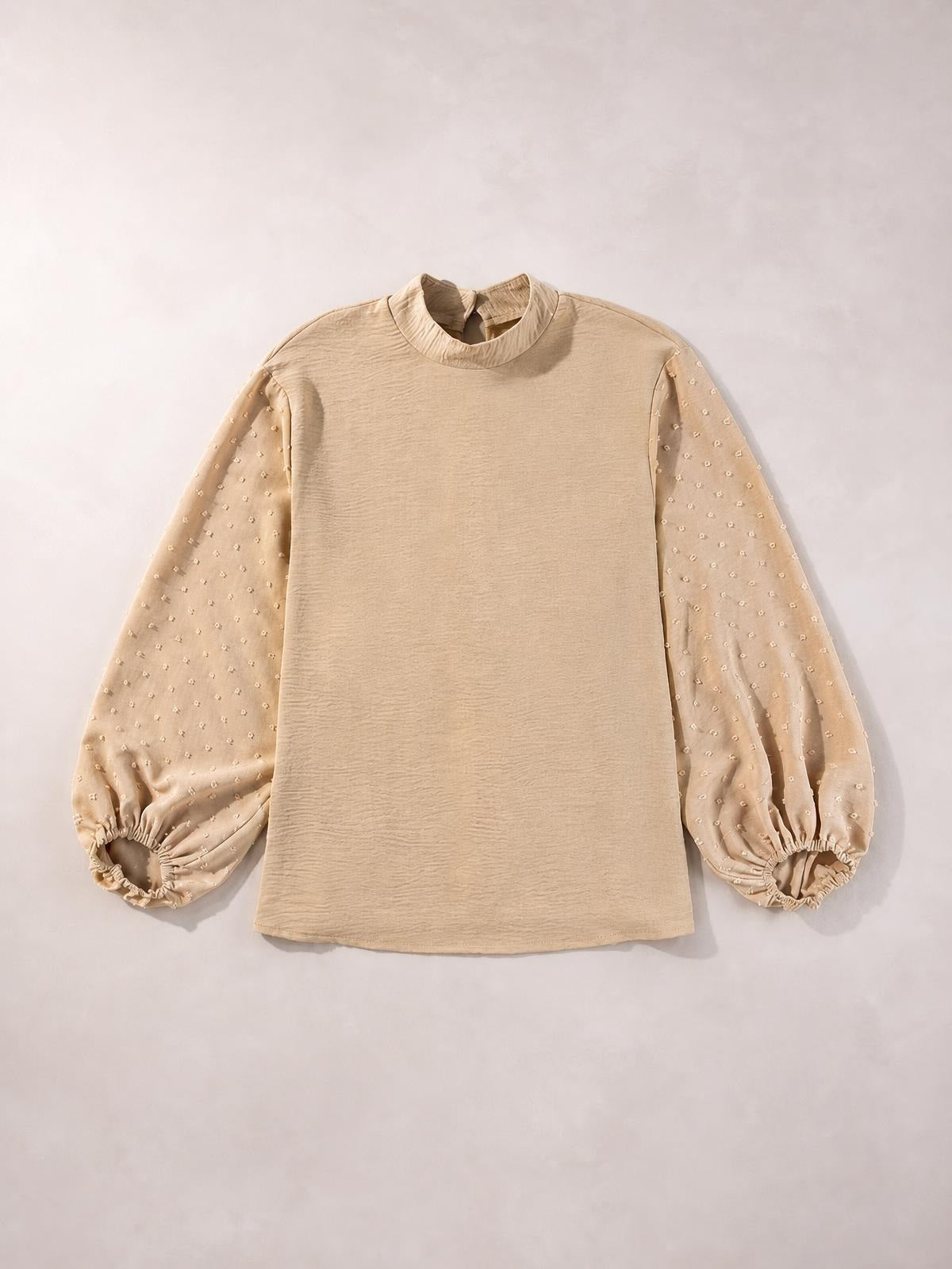 Beige Swiss dot mock neck blouse with voluminous balloon sleeves, gathered elastic cuffs, and a relaxed straight silhouette.