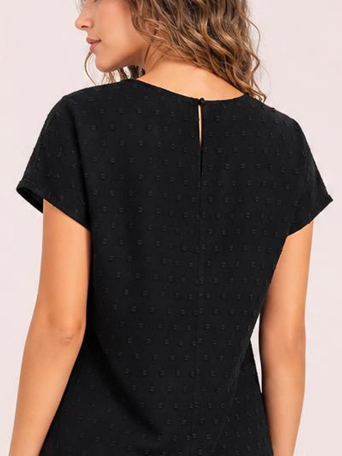 Model shown from behind wearing a black Swiss dot crochet top with a round neckline, short sleeves, relaxed silhouette, and buttoned keyhole closure.