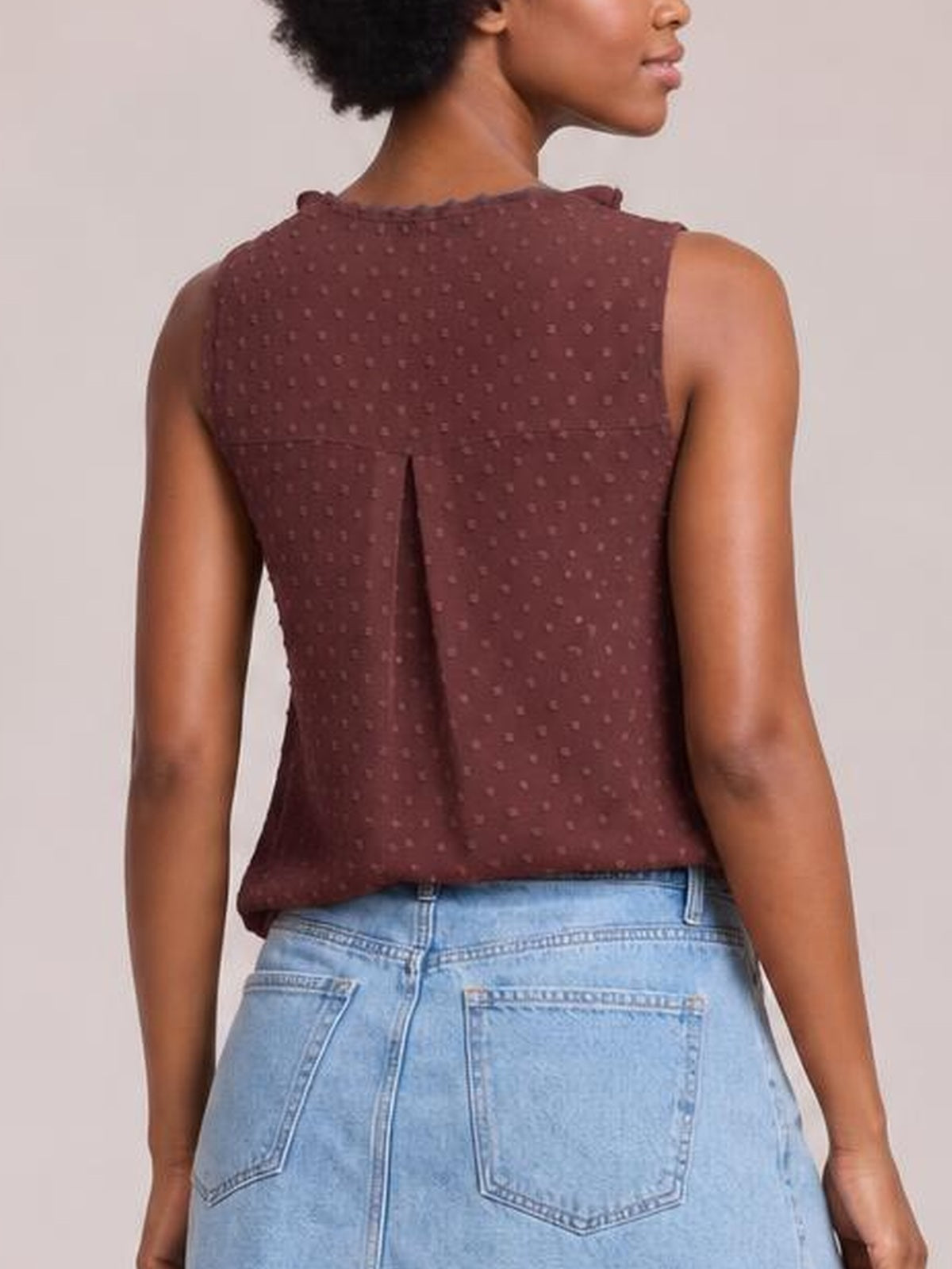 Model shown from the back wears a burgundy Swiss dot tank with ruffled wide straps, a relaxed silhouette, and a center back pleat.