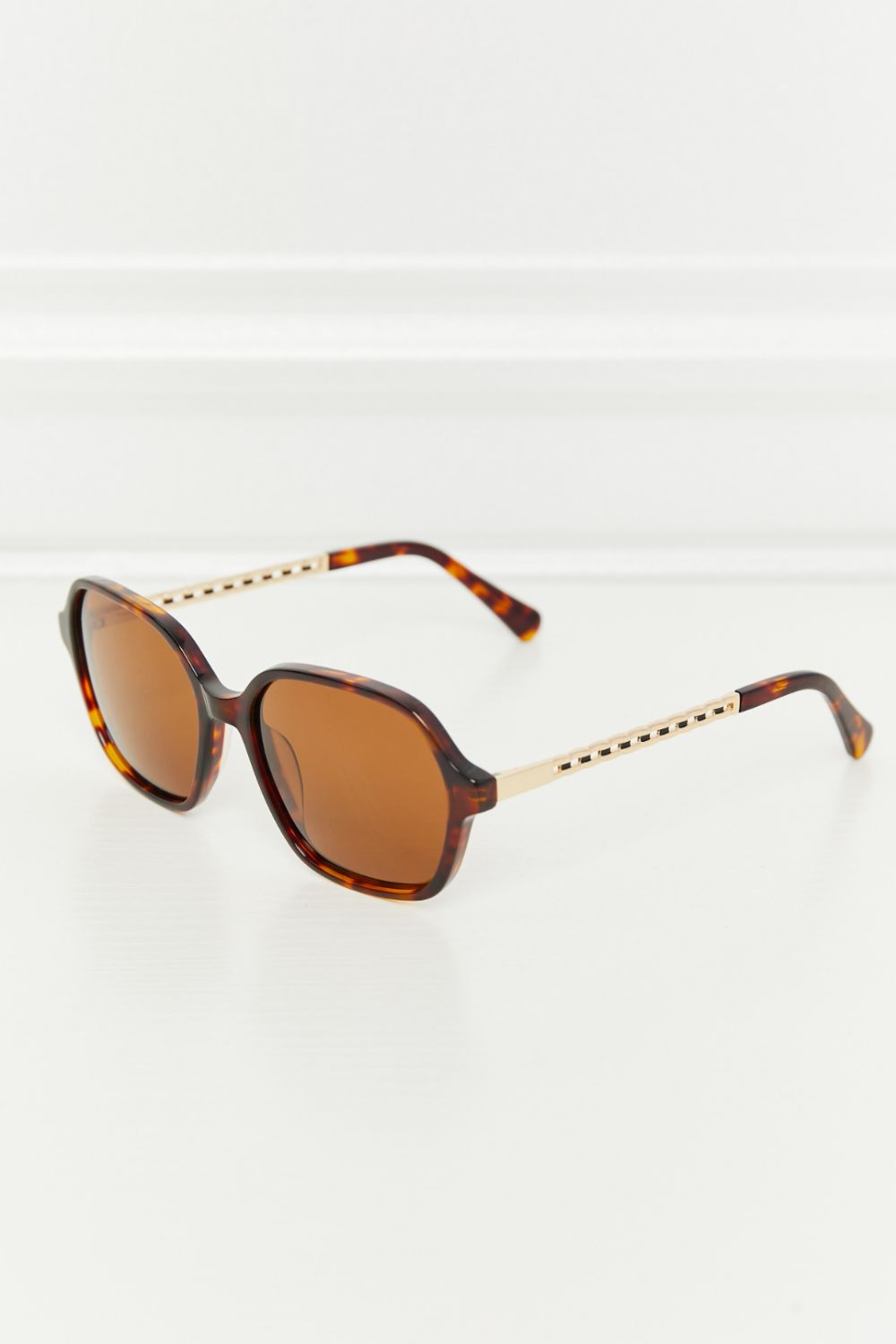 Brown full-rim square TAC polarized sunglasses feature warm brown lenses, a sculpted acetate frame, and contrasting metal-acetate temples shown at an angle.